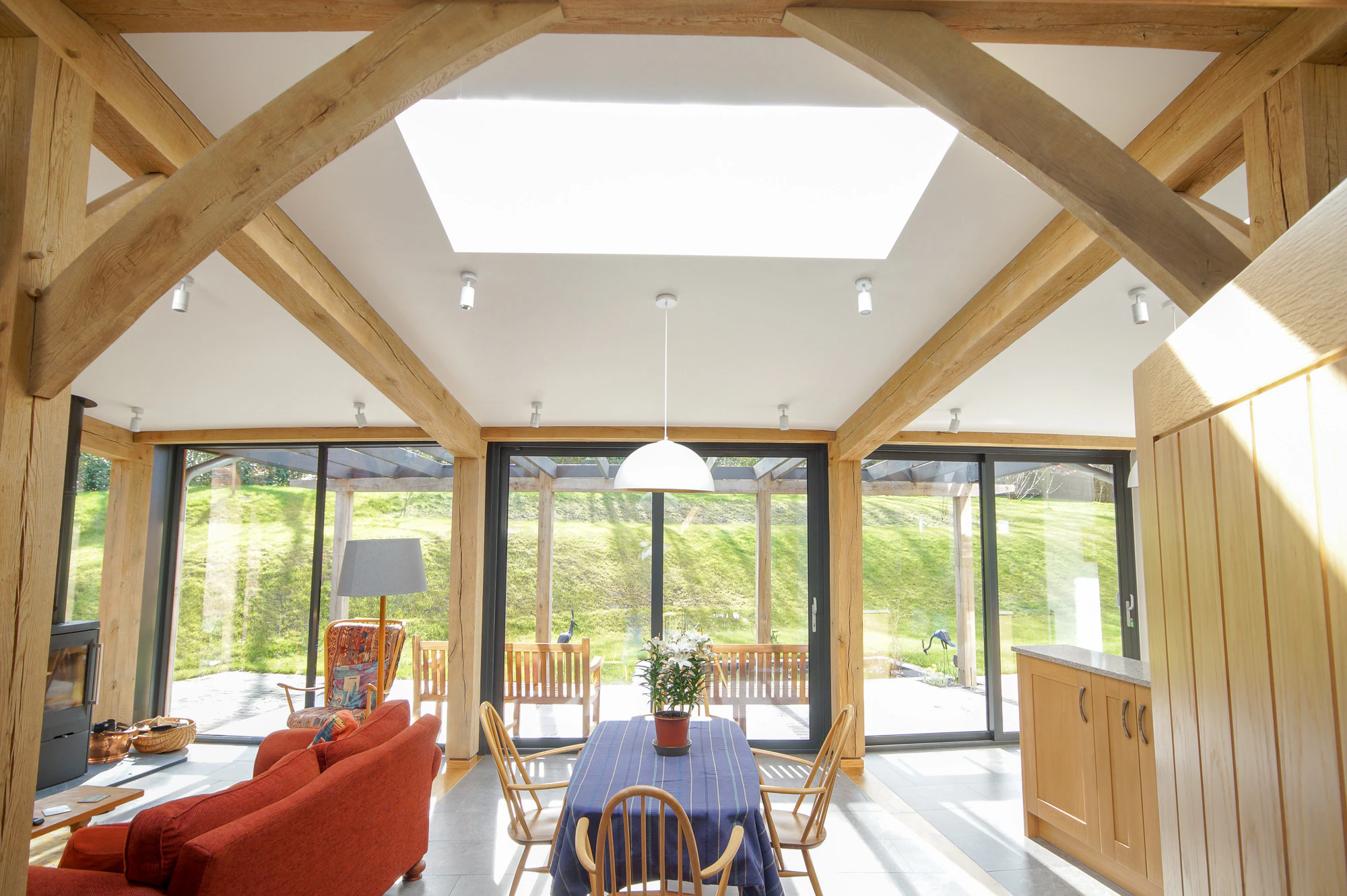 An open plan living room, kitchen, dining area in a curved oak frame home