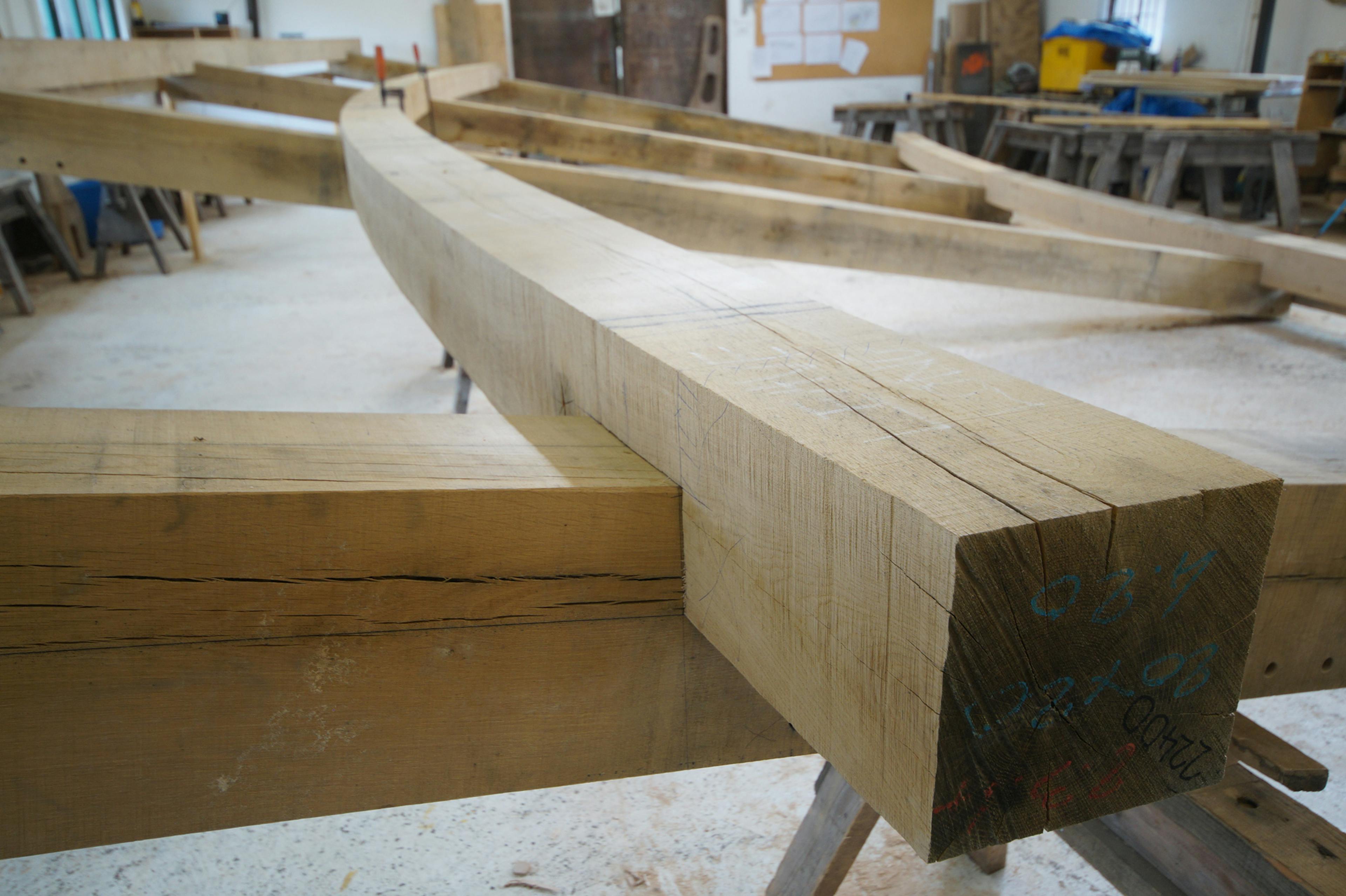 A curved oak frame during construction in a carpenters workshop