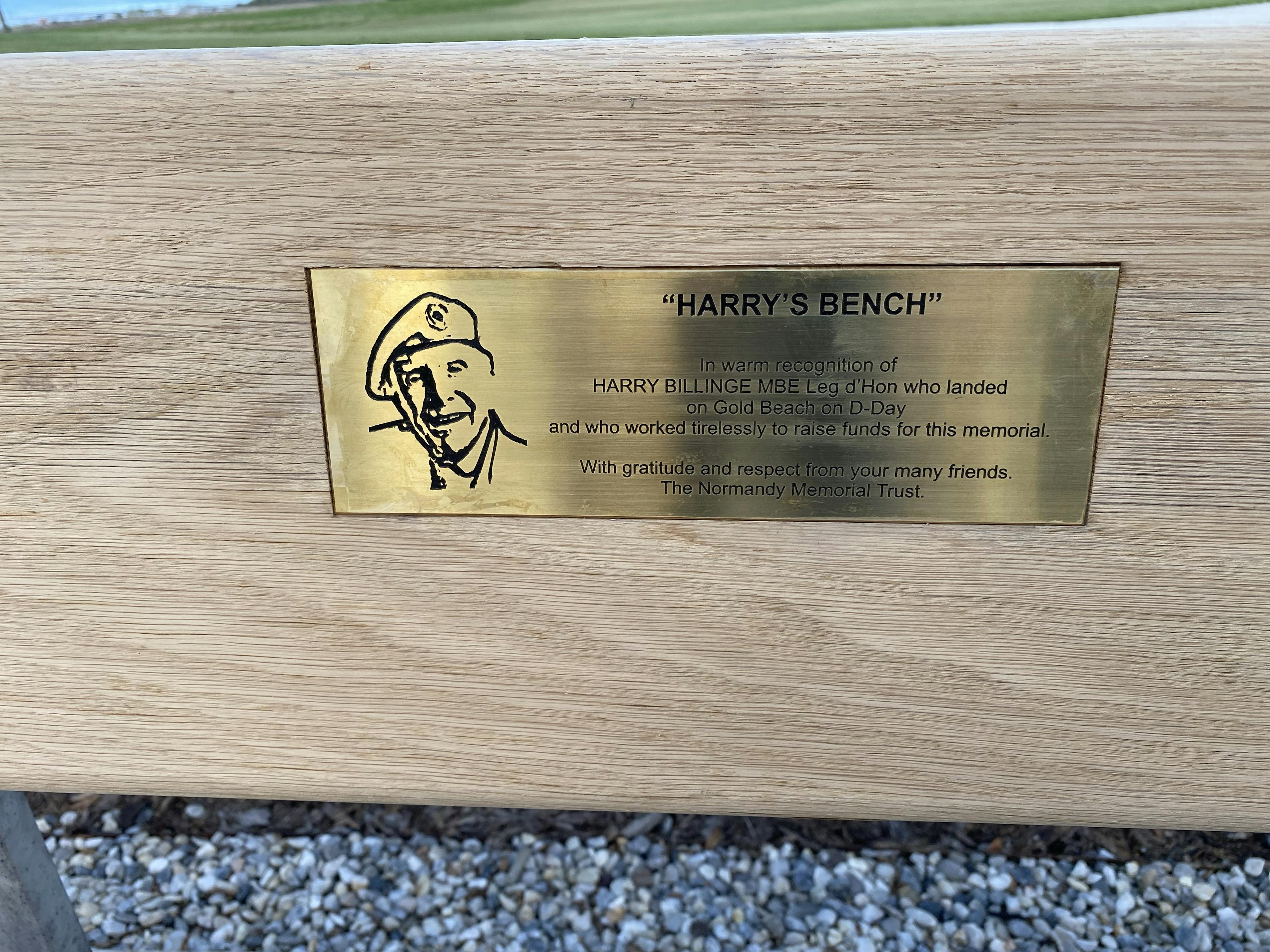 A gold plaque on a bench for veteran Harry Billinge at the British Normandy Memorial