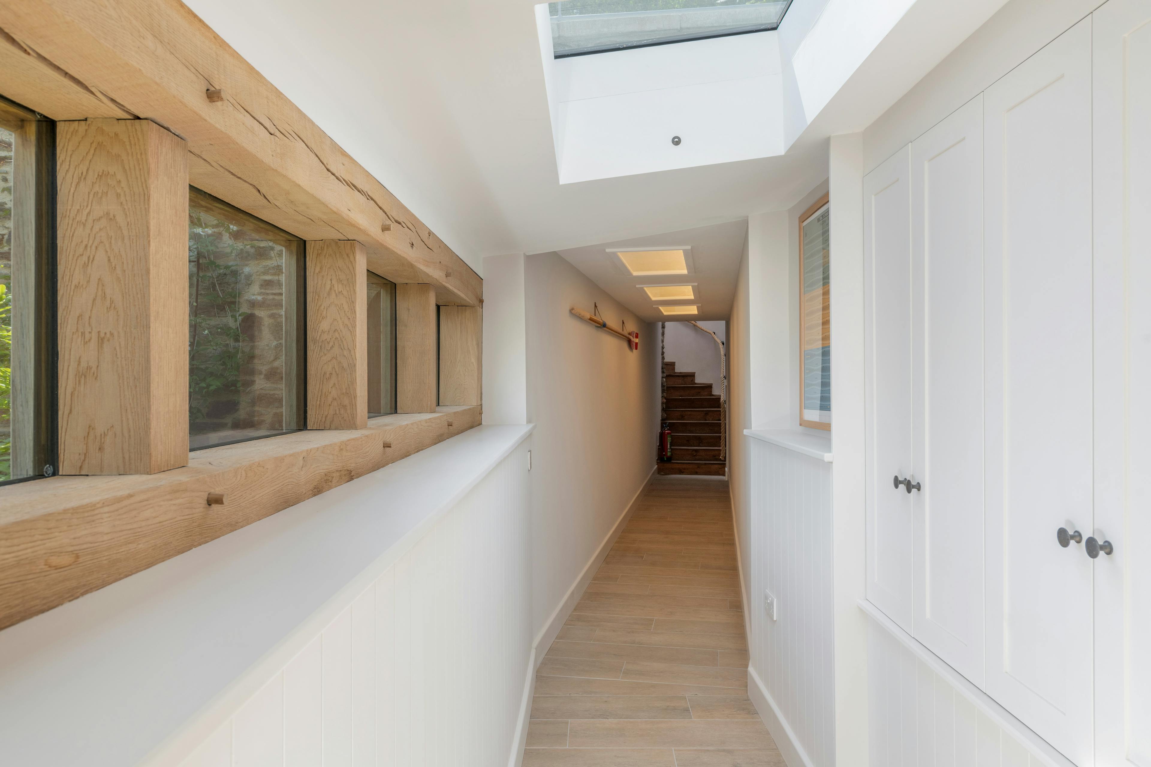 An oak framed corridor with sunshine coming through the rooflights