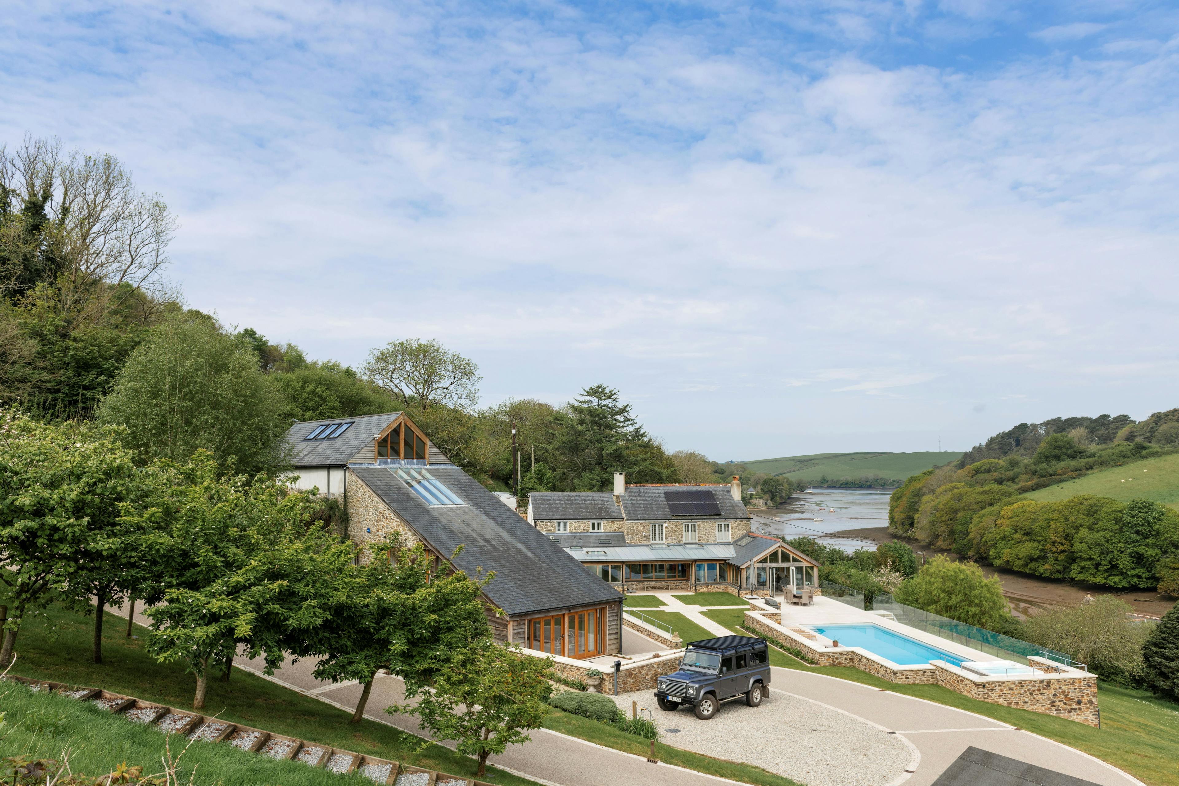 A renovated cottage on an estuary with a a swimming pool, green lawn and oak framed garden room, entrance and corridor extension