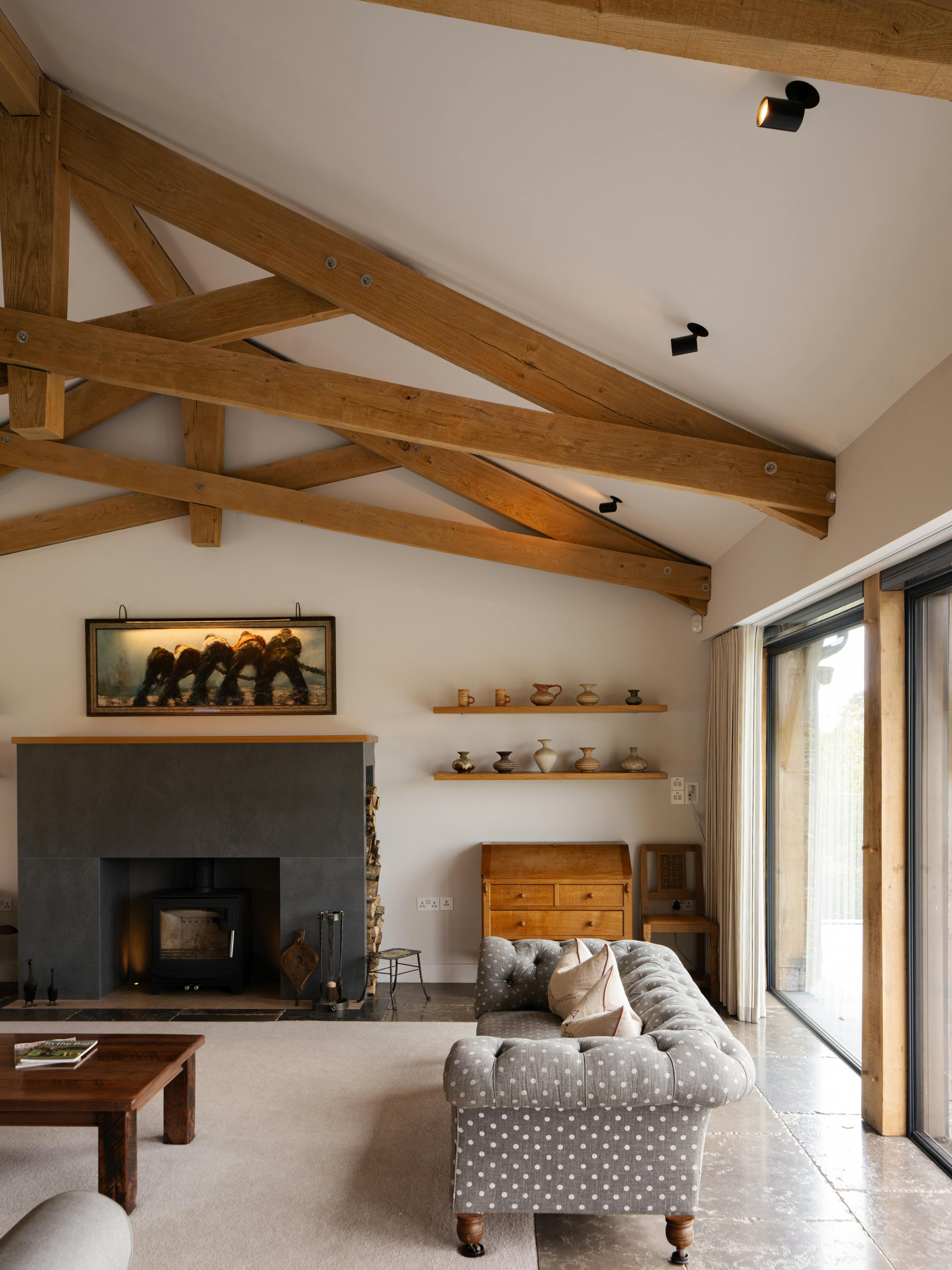 An oak framed living room with feature scissor trusses and a log burner