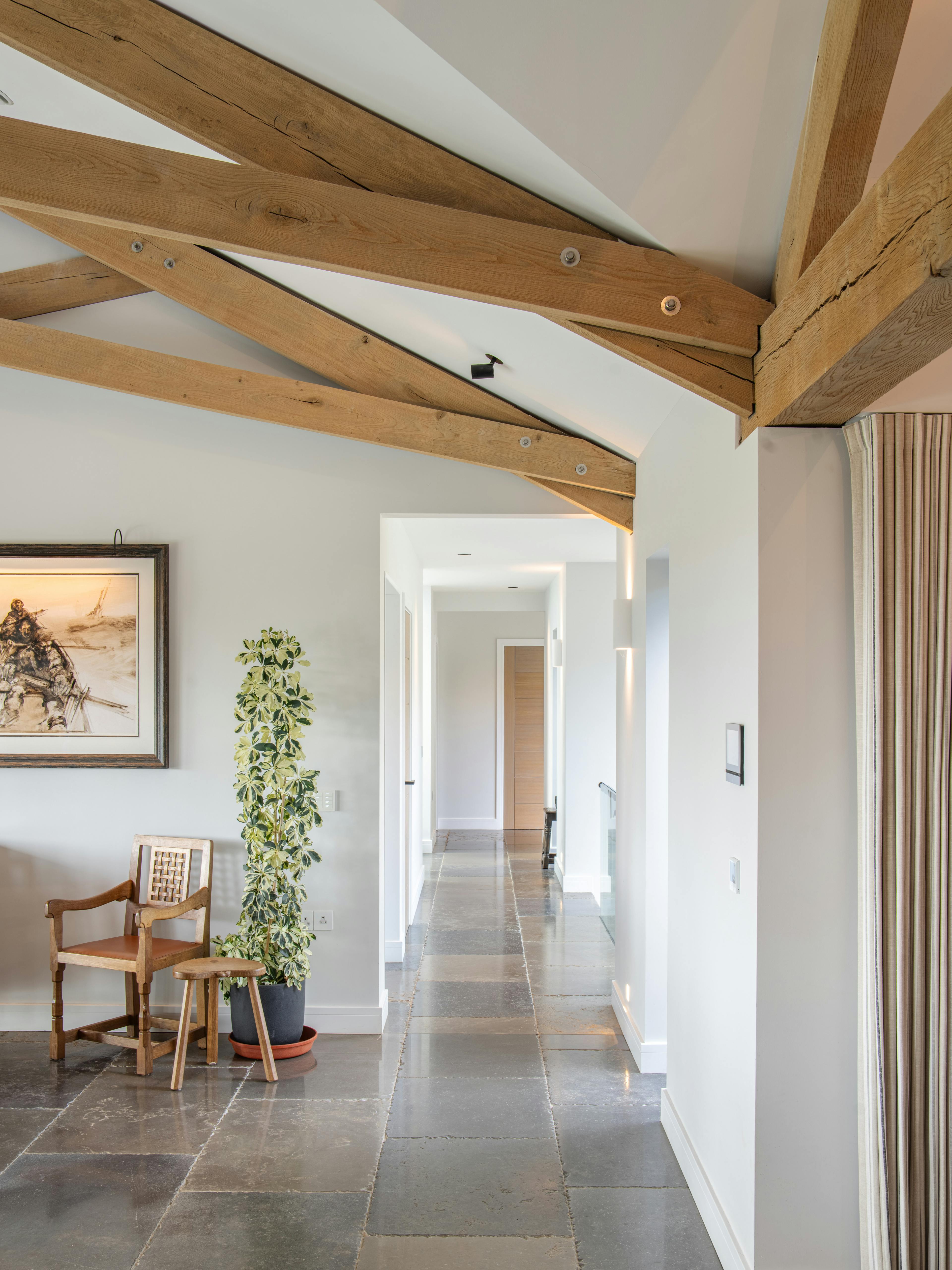 A large oak framed hallway with a scissor truss