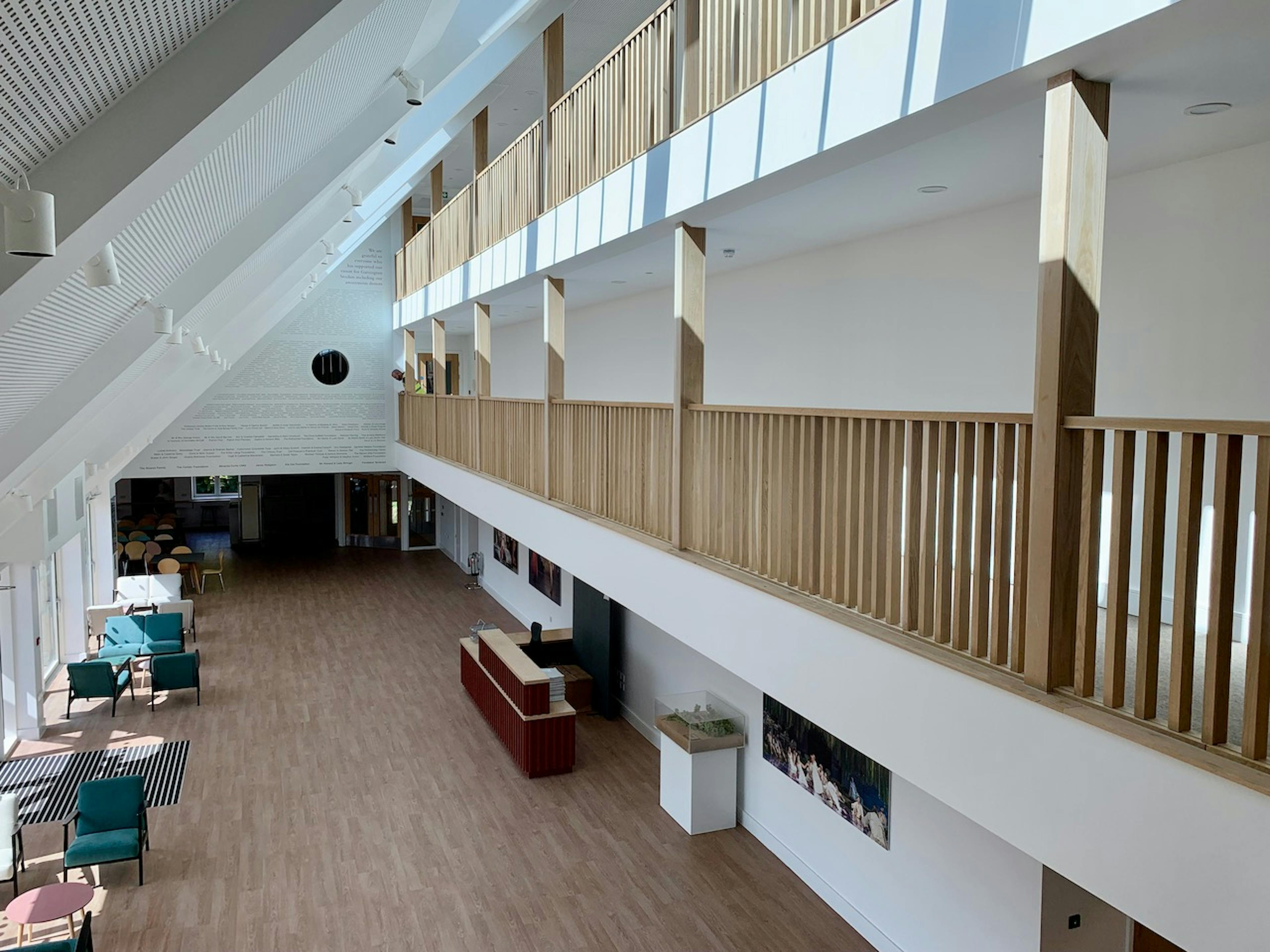 Interior view of a cafe with 2 levels of upper wooden balustrading below a sloped ceiling