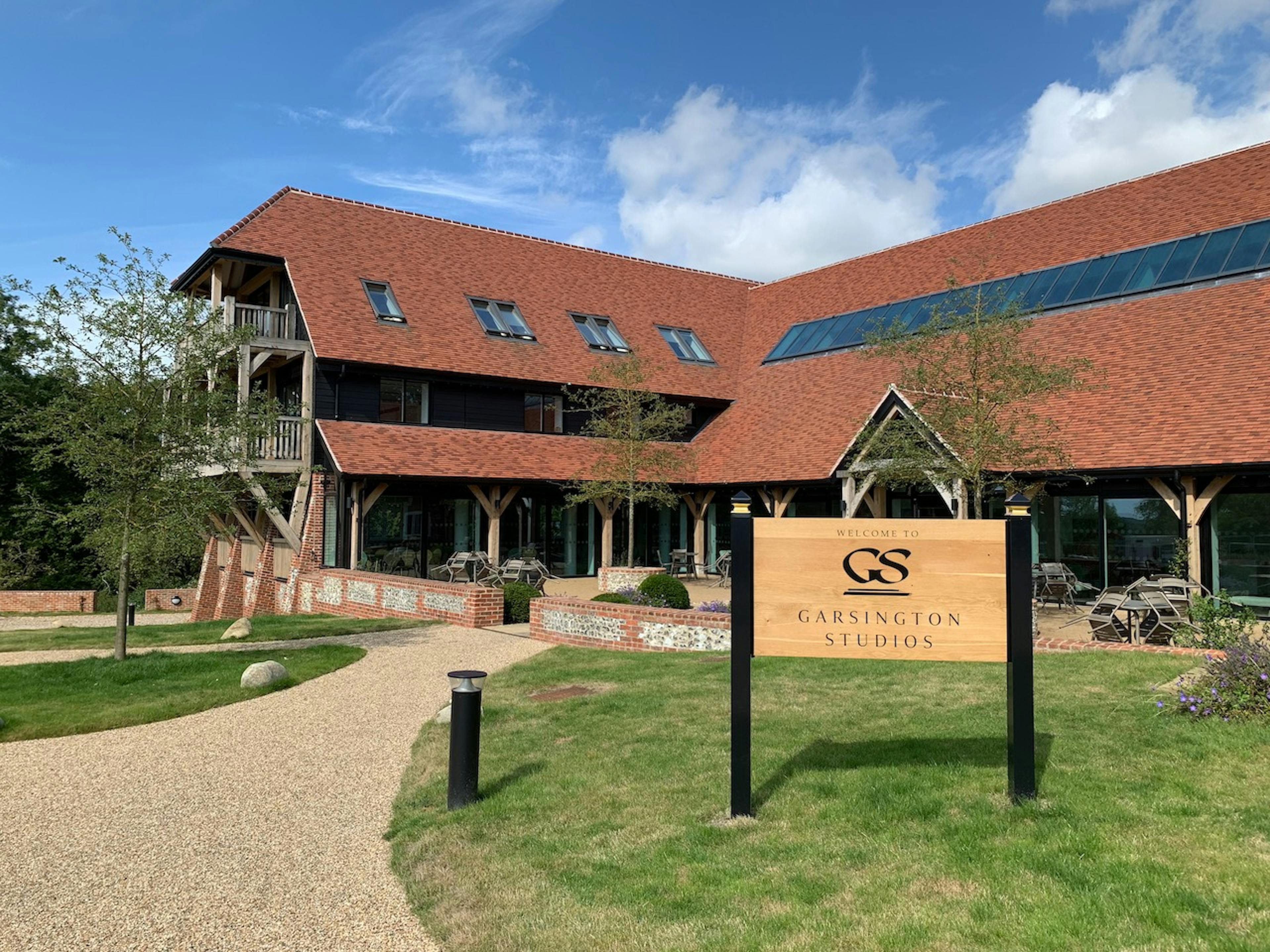 A courtyard with oak posts, oak porch and oak balcony on a large red roofed building