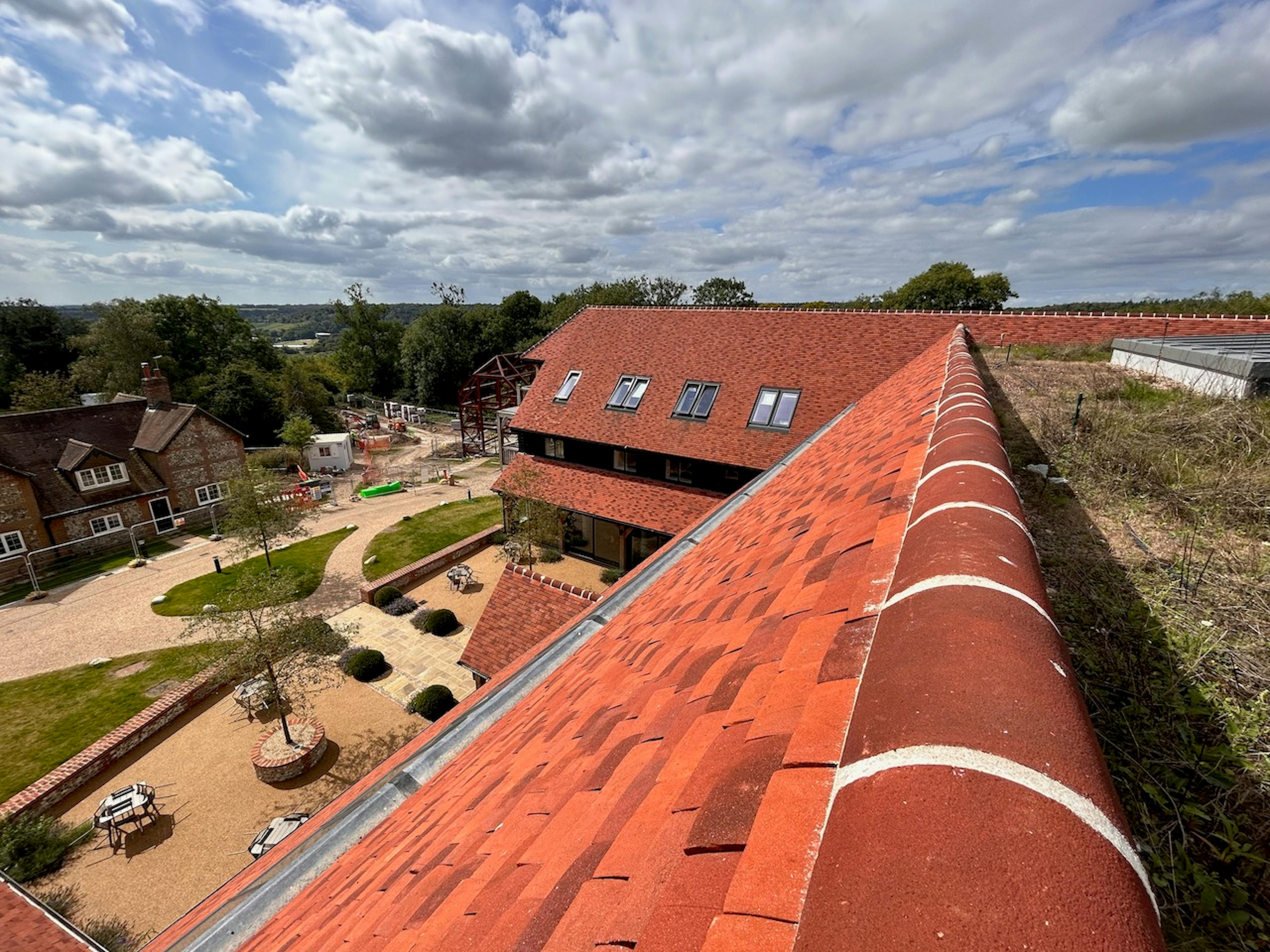 A courtyard below a large red roofed building, taken from the roof