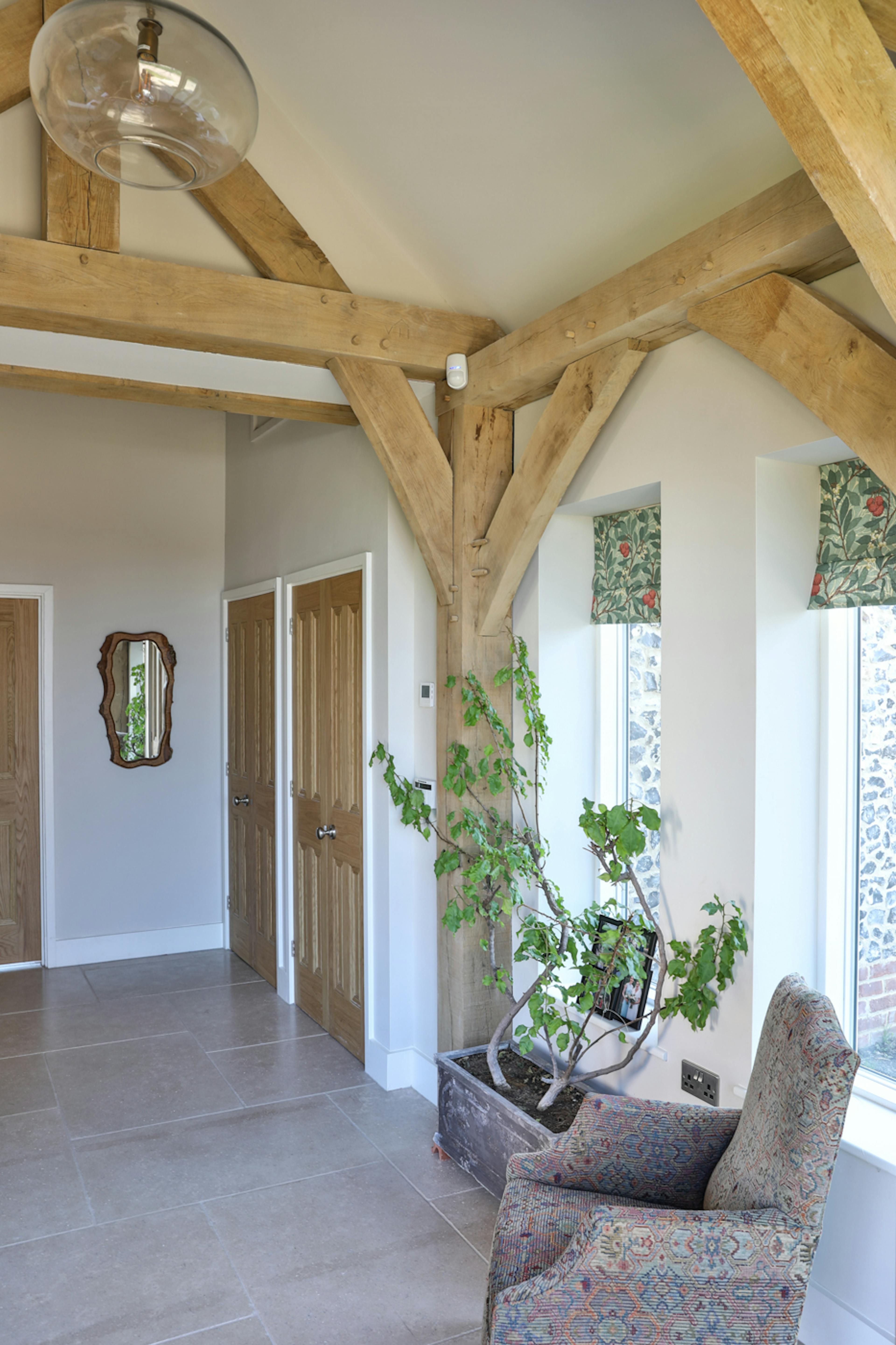 An oak framed entranceway with plants and chairs