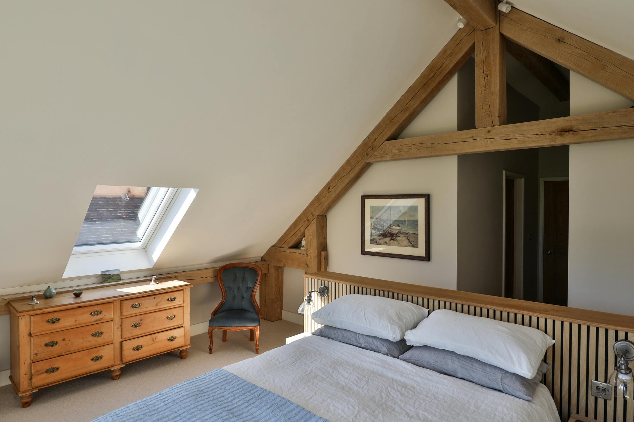 An oak framed bedroom in the attic with sloped ceilings