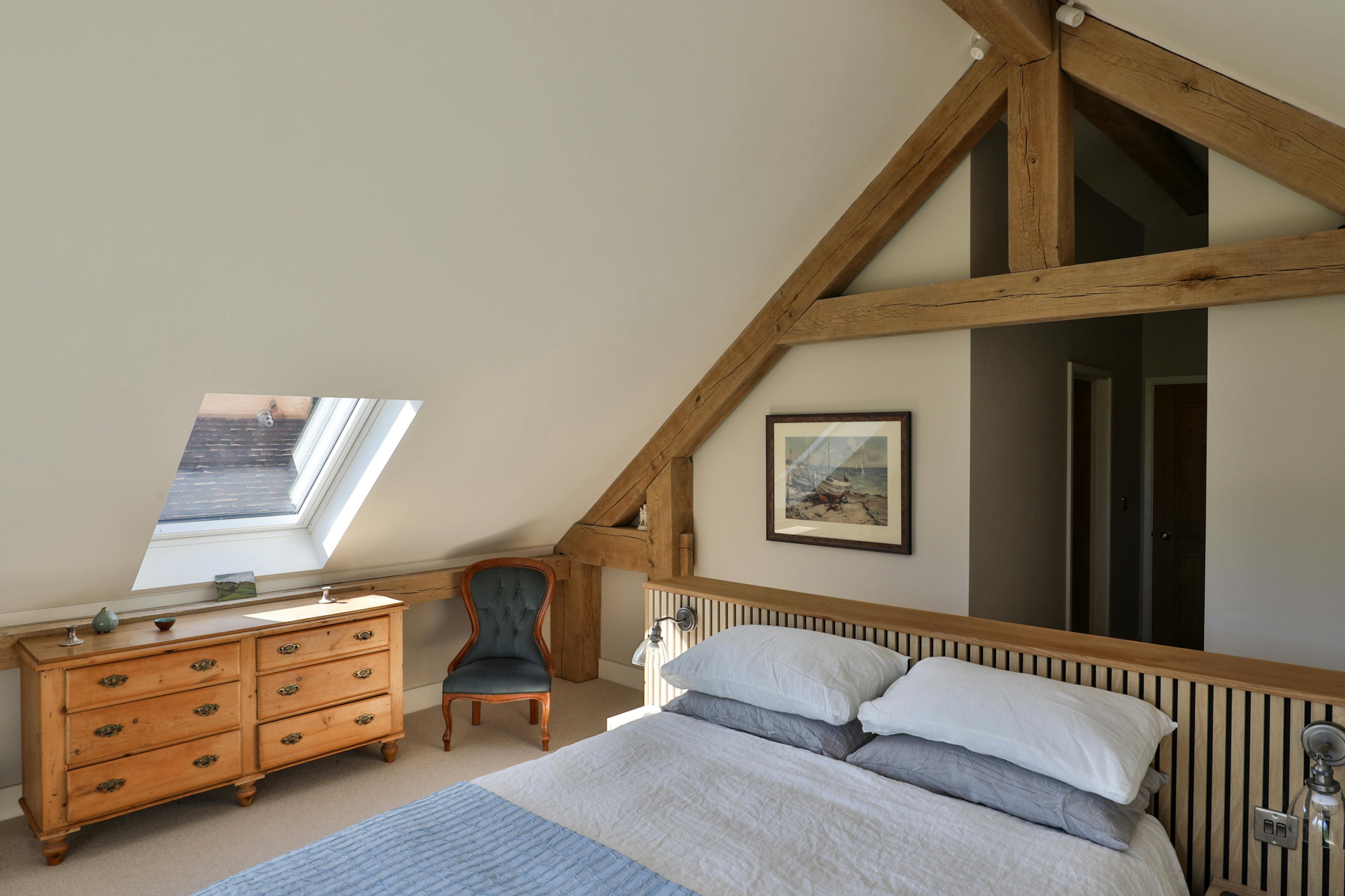 An oak framed bedroom in the attic with sloped ceilings