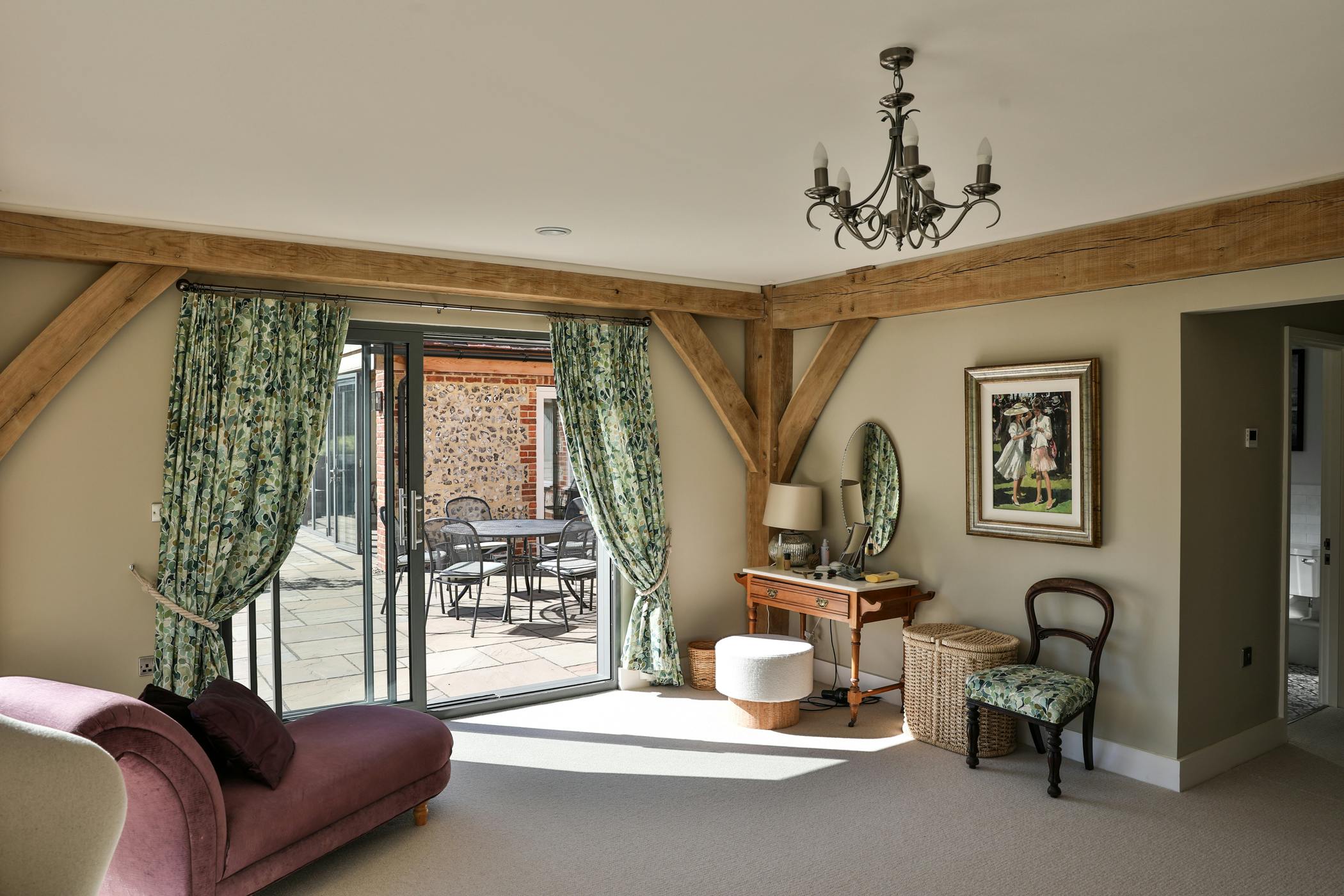 An oak framed bedroom with sliding doors to a sunny patio