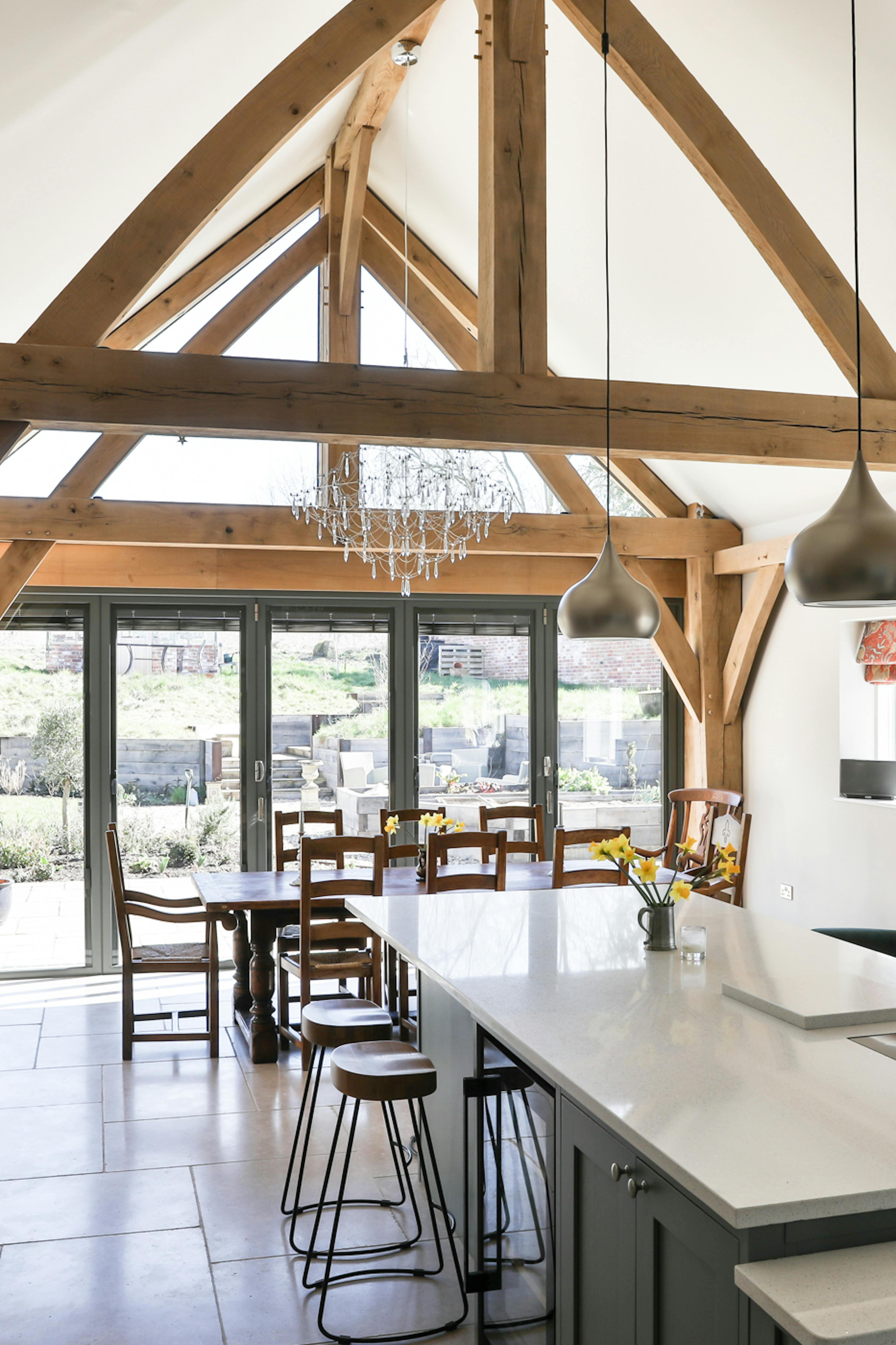 An open plan vaulted oak framed kitchen diner with an island and breakfast bar