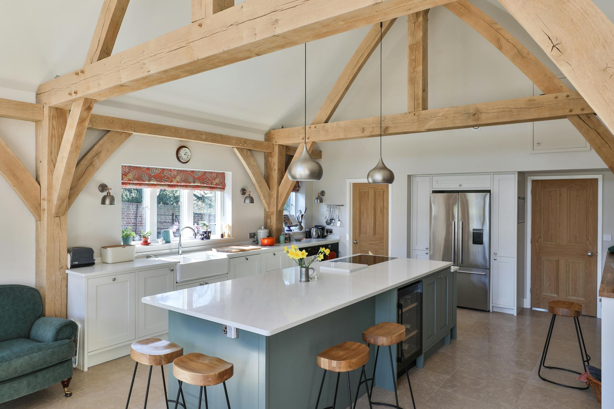An open plan vaulted oak framed kitchen with an island and breakfast bar