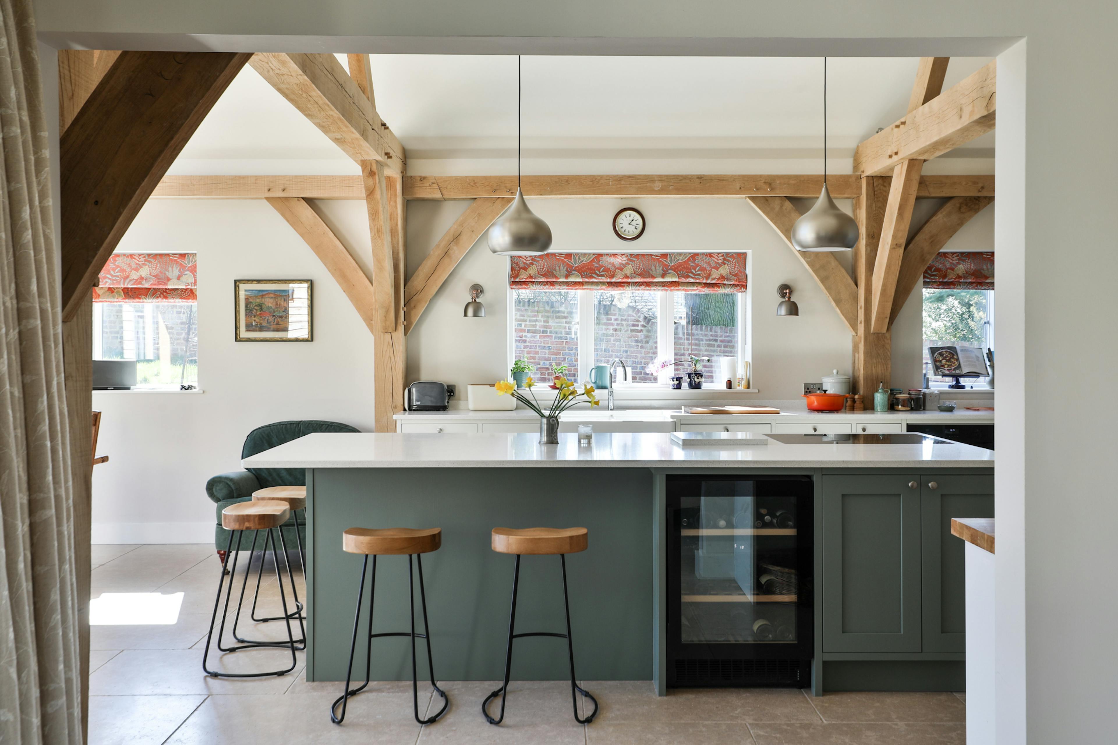 An open plan vaulted oak framed kitchen with an island and breakfast bar