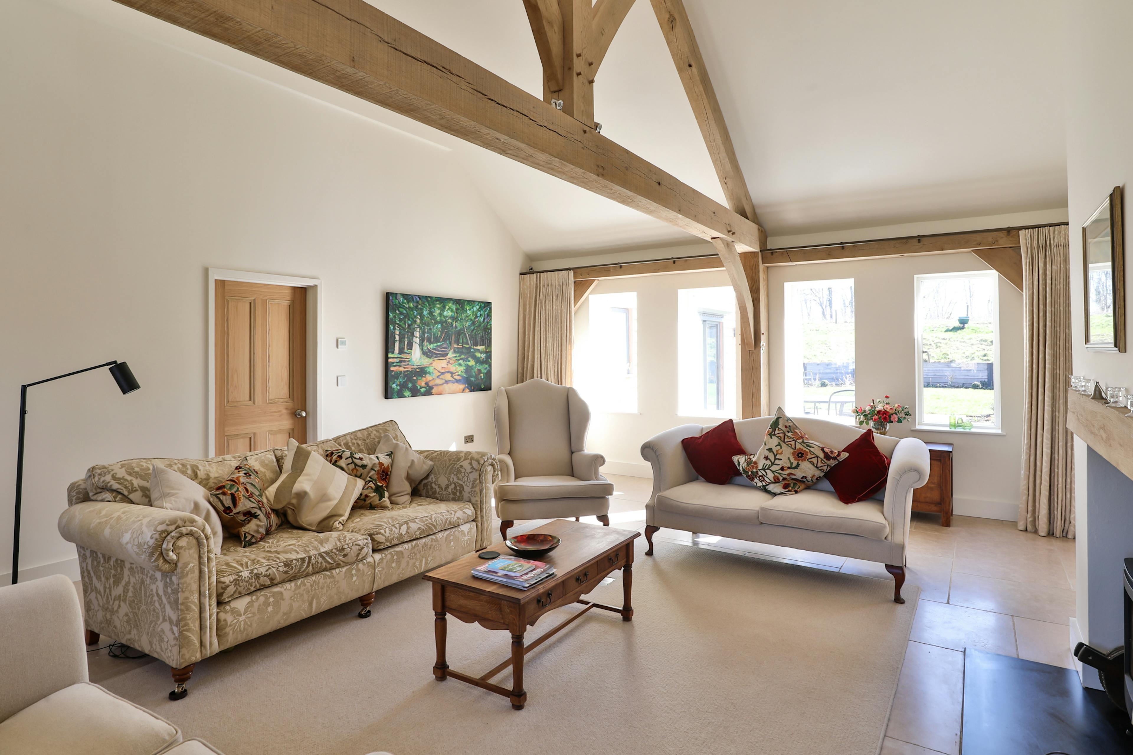 An oak framed lounge with comfortable sofas and a log burner