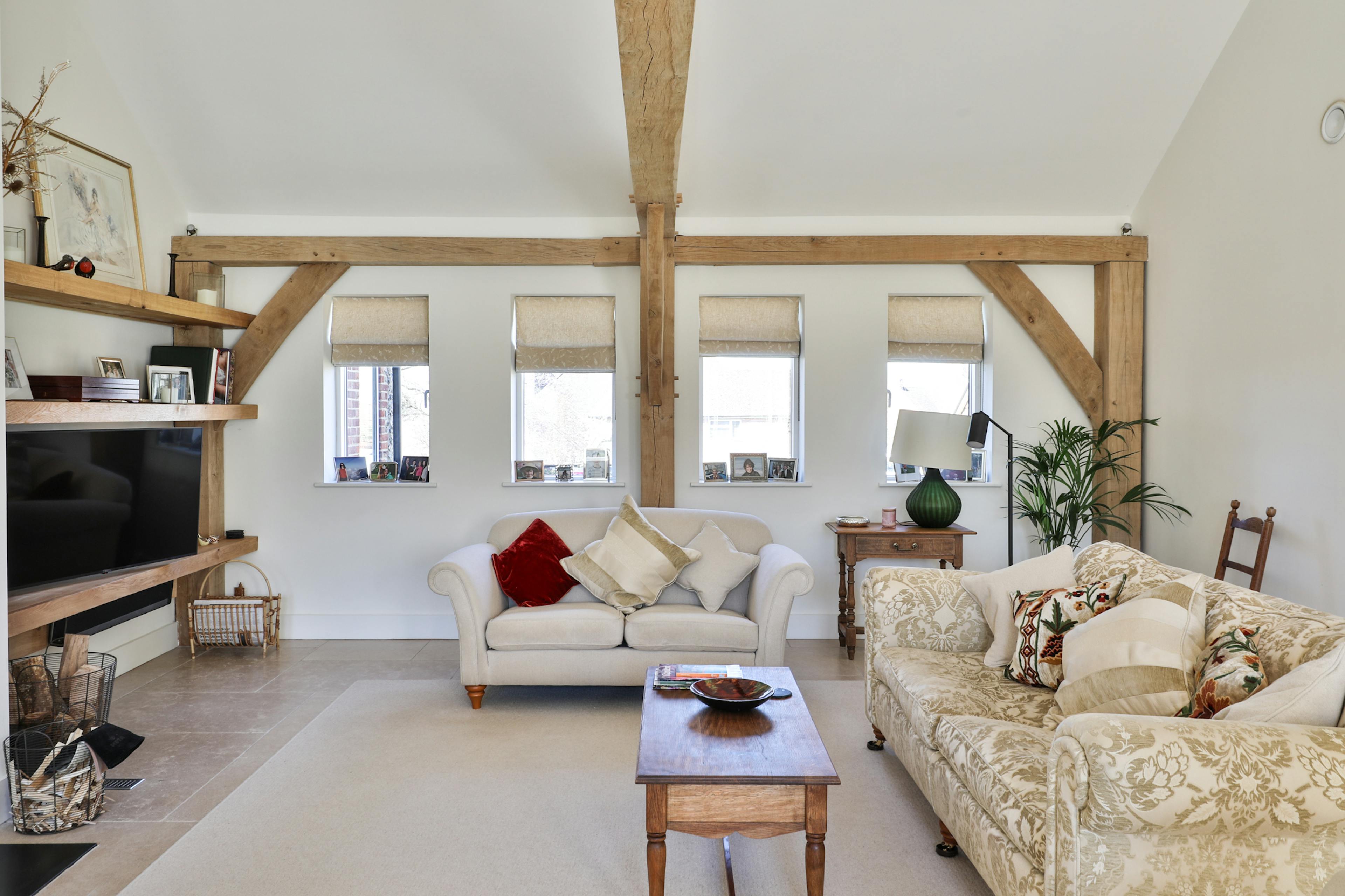 An oak framed lounge with comfortable sofas and a TV