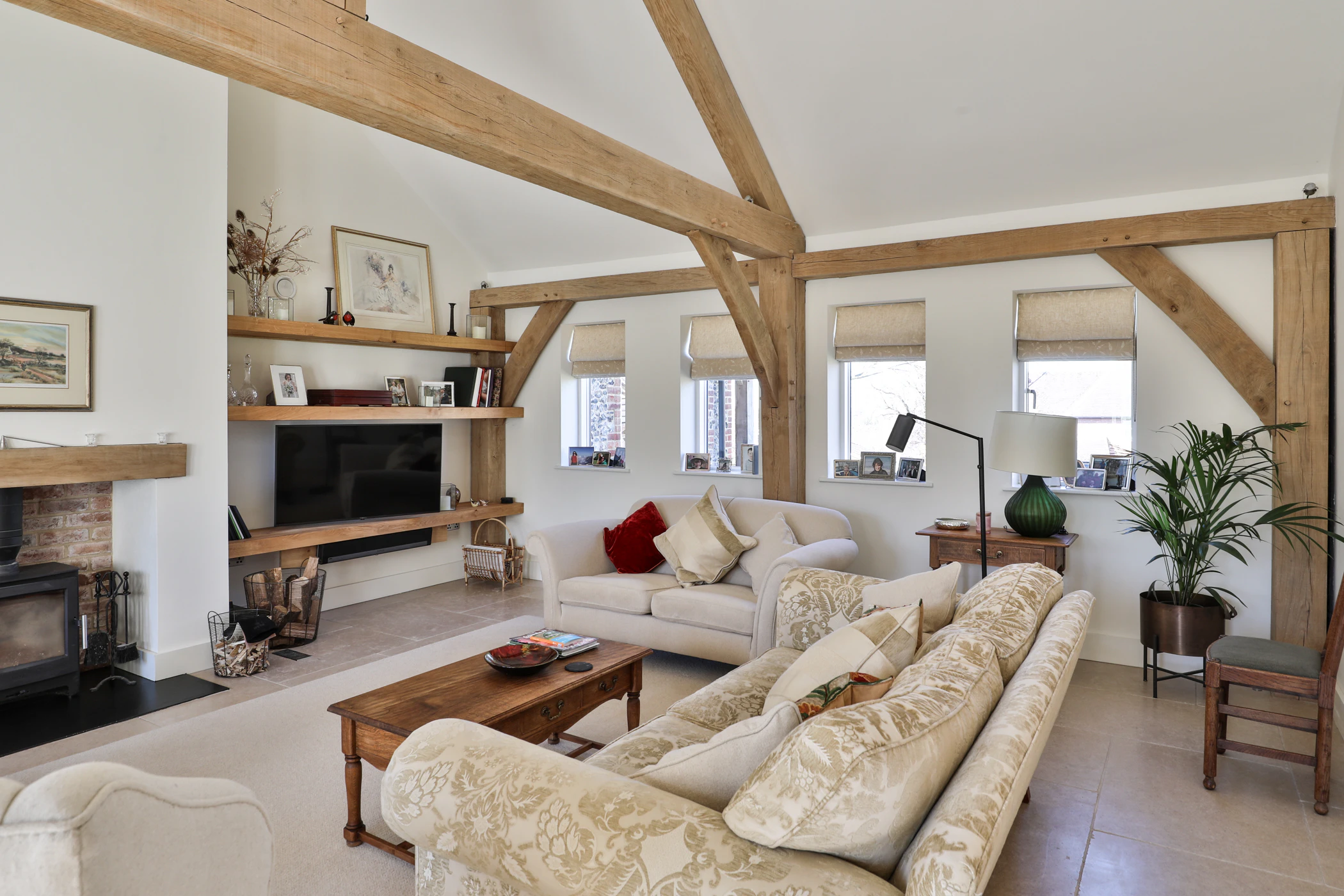 An oak framed lounge with comfortable sofas and a log burner