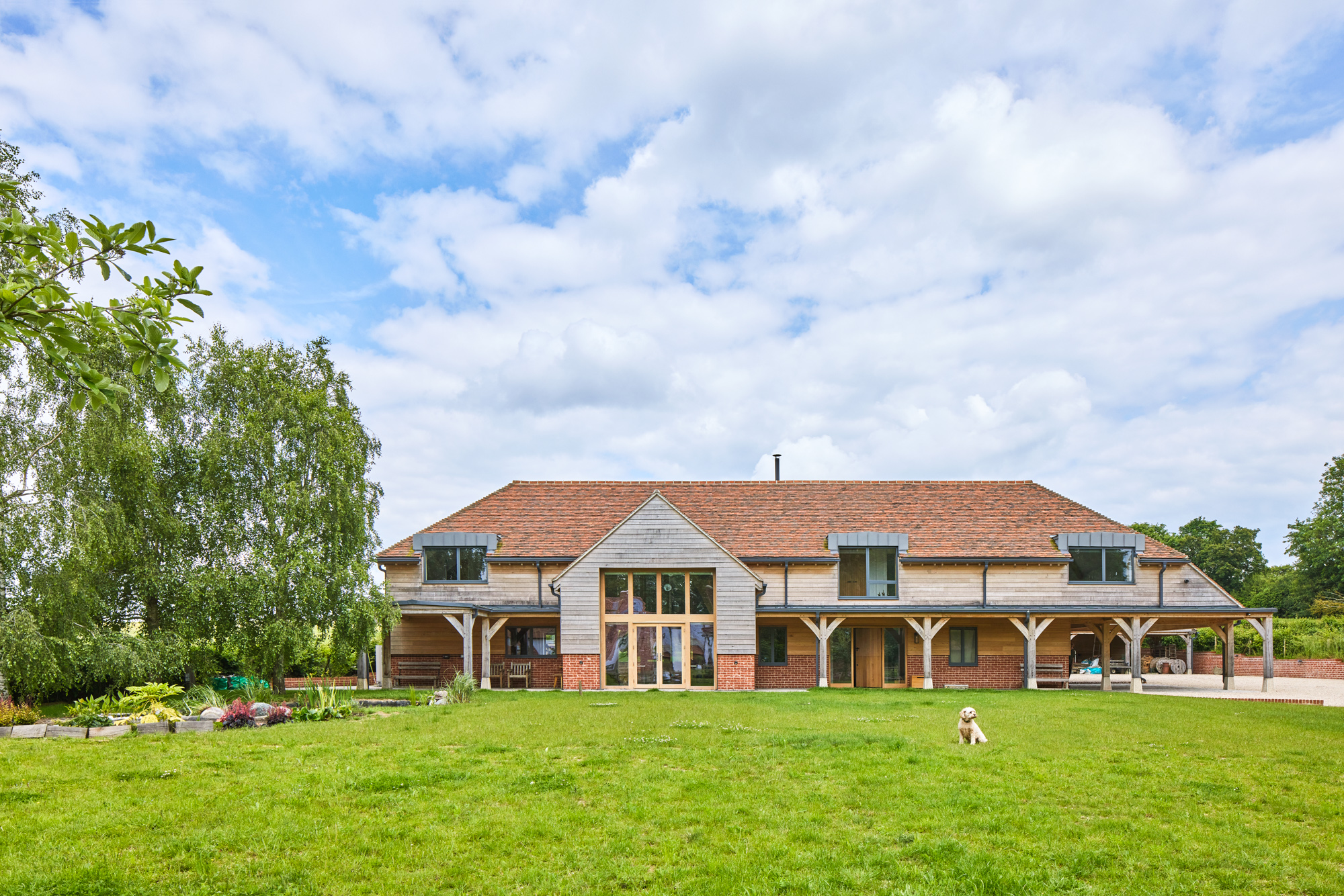 Large oak frame house with green grass lawn in front