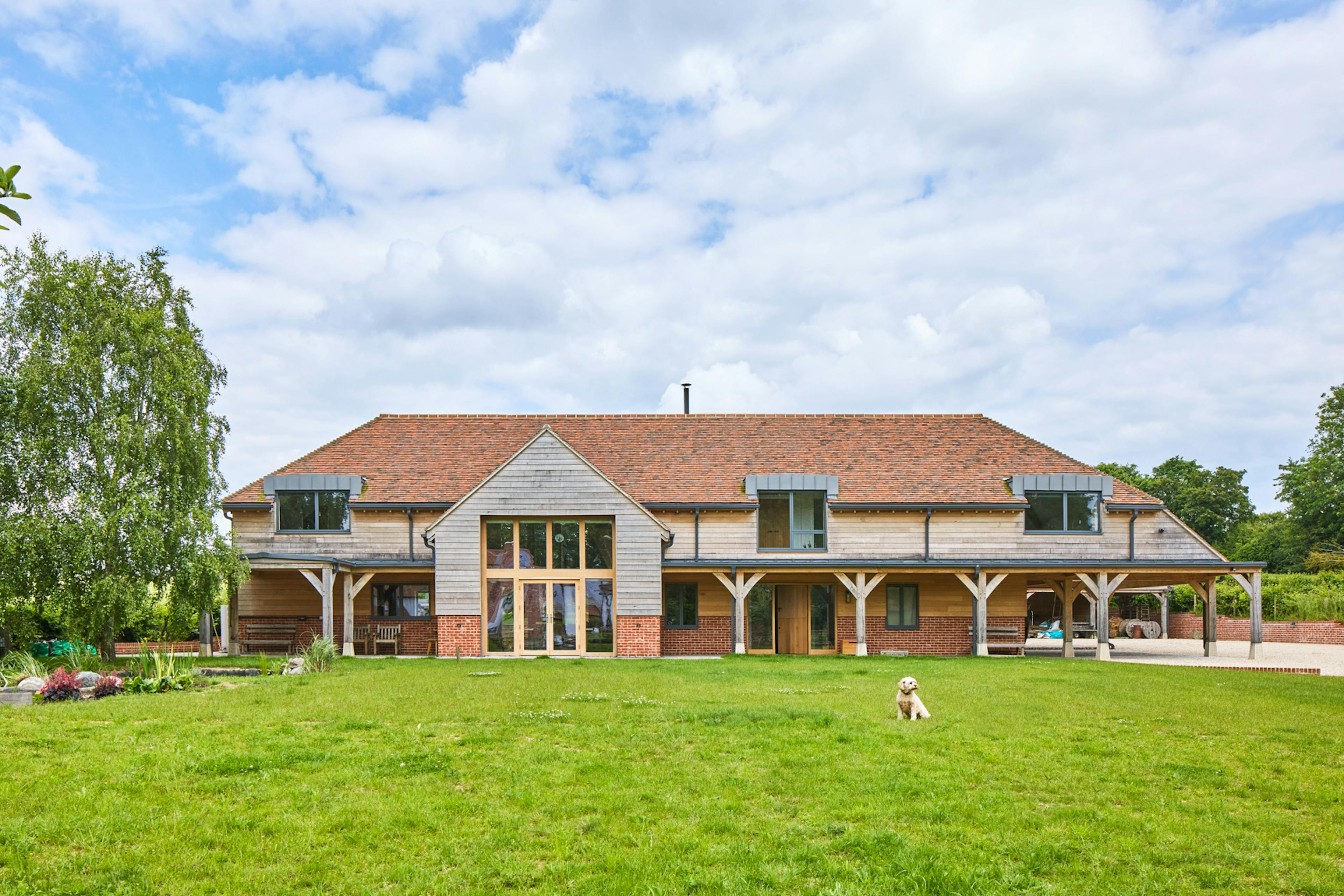 Large oak frame house with green grass lawn in front