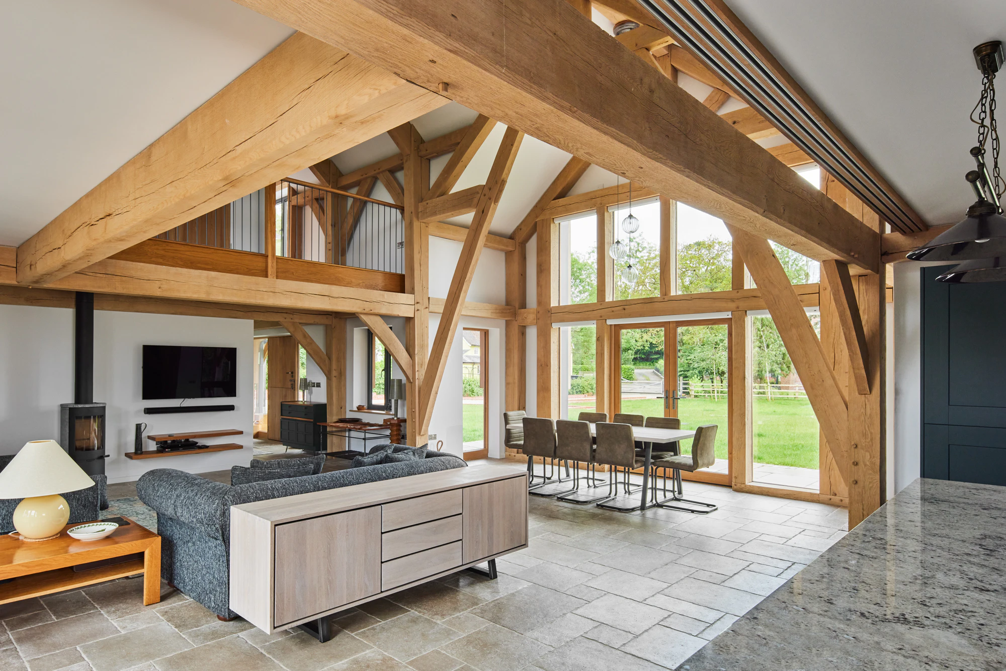 A large open plan living and dining space with vaulted ceilings and a glazed gable end in a large oak framed home