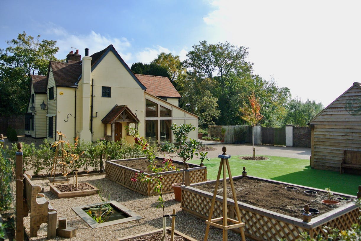 An old house with an oak extension set in a landscaped garden