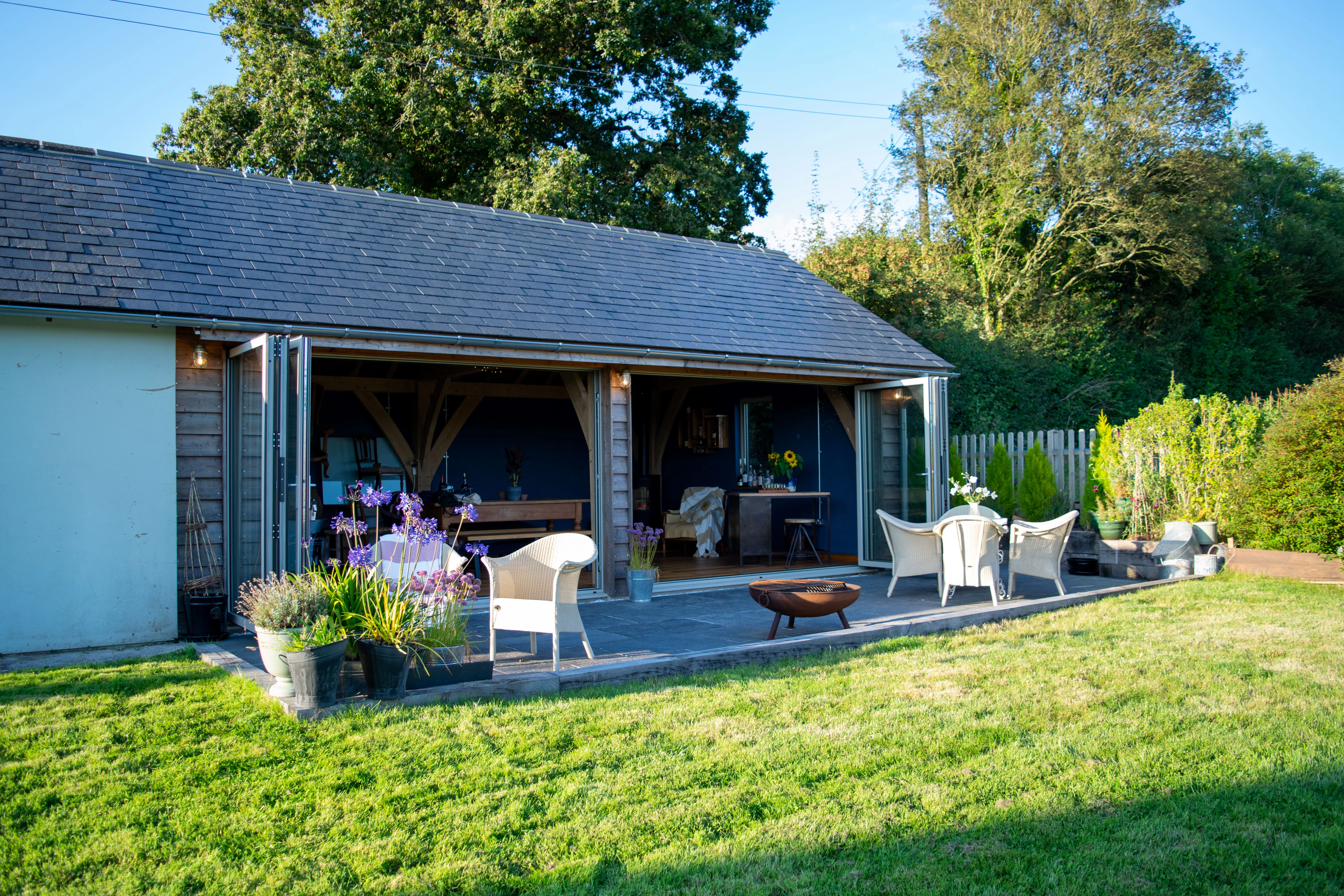 An oak framed extension in a garden with a green lawn