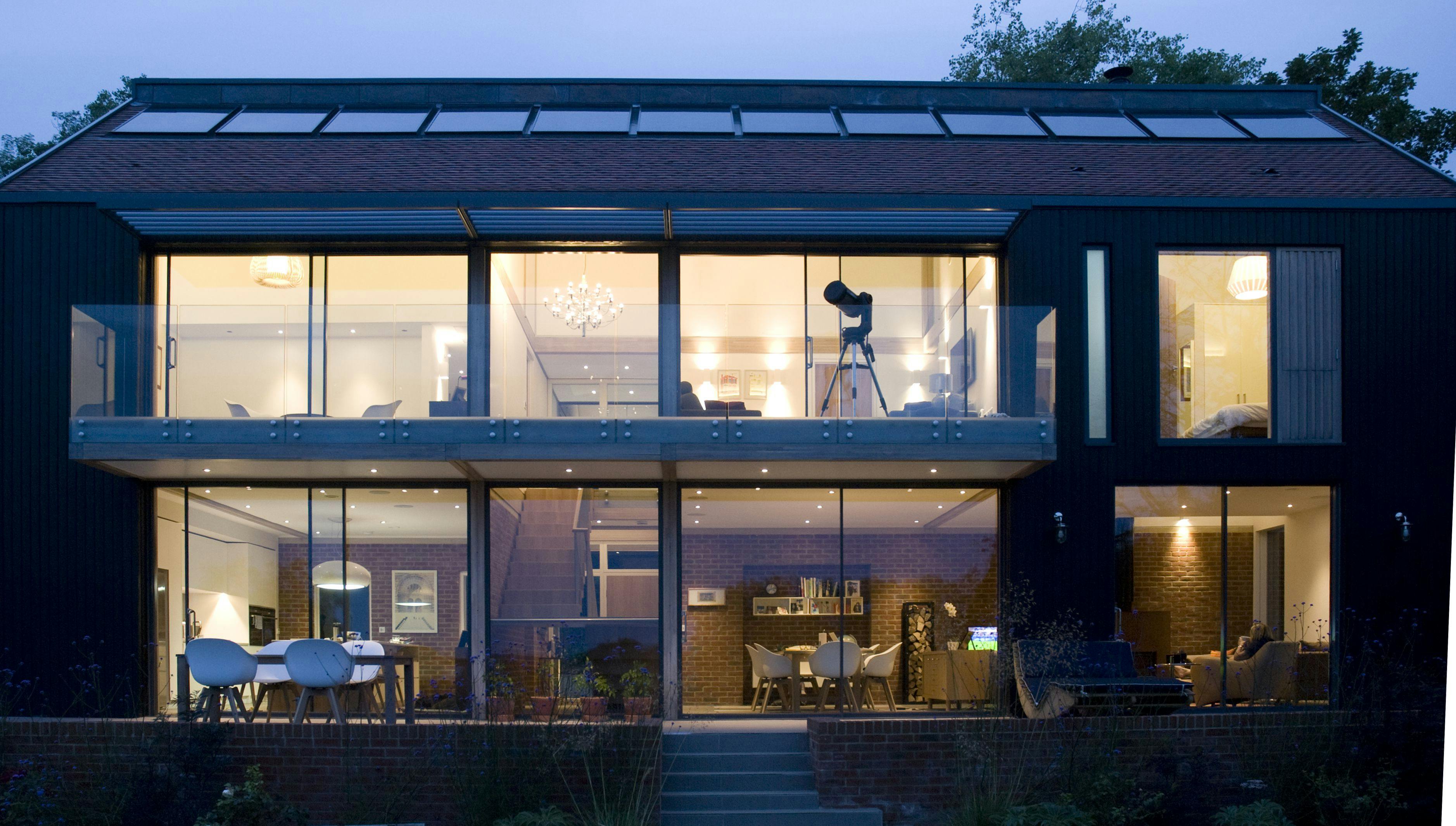 External image of glulam timber framed home at night