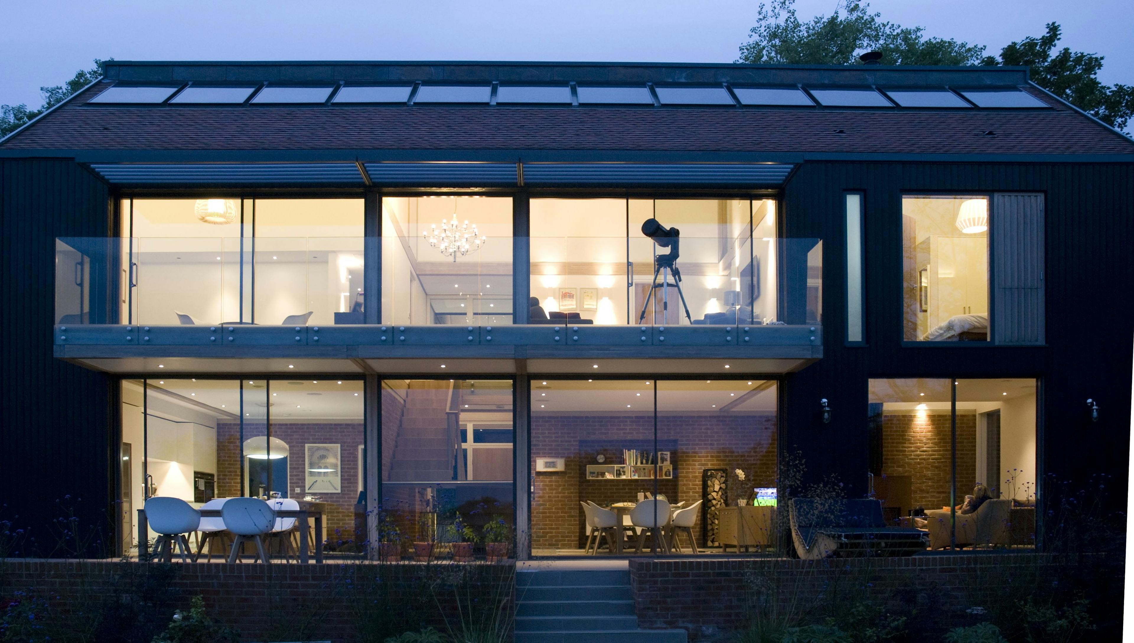 External image of glulam timber framed home at night