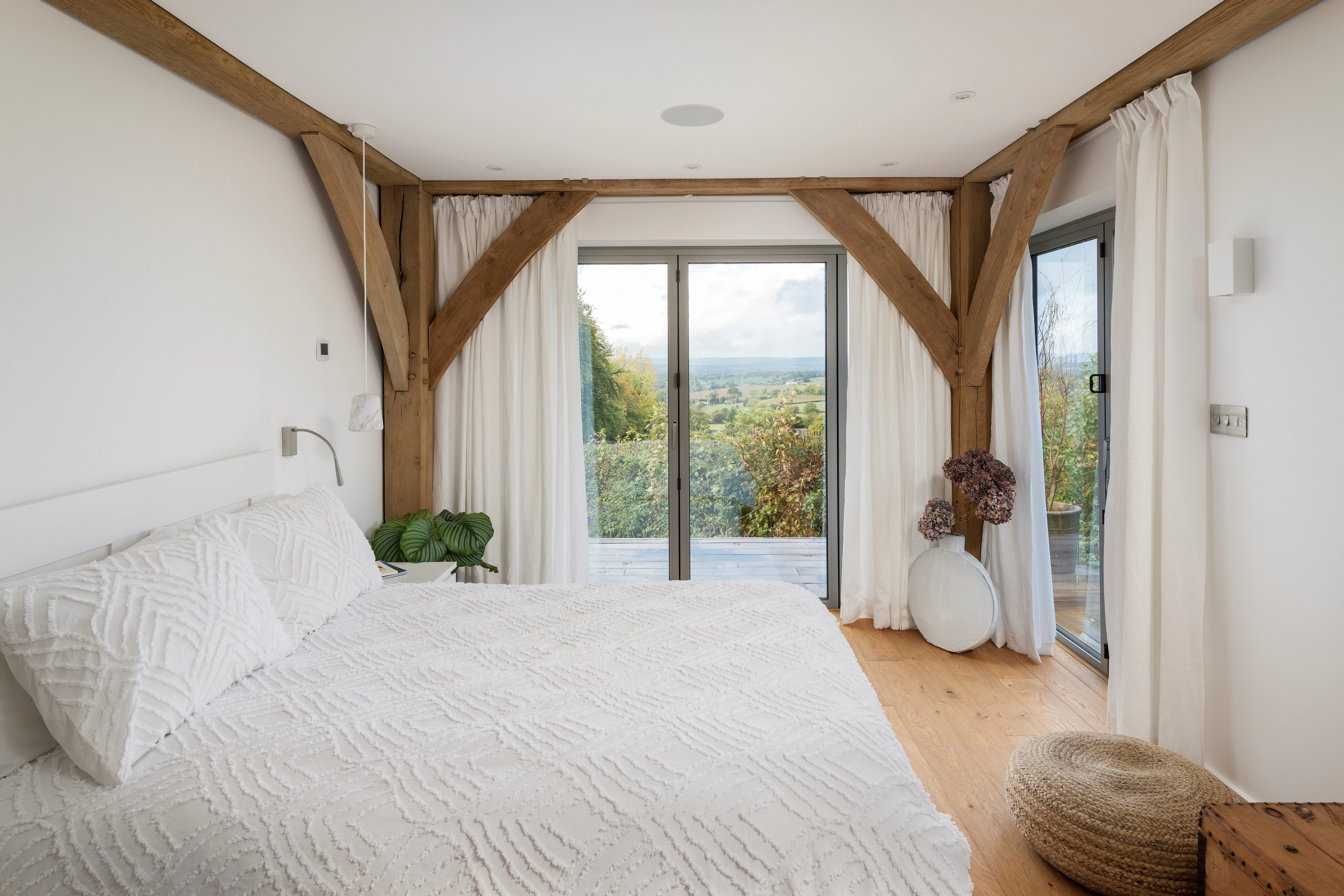 Oak framed bedroom with large glazed doors and views of the countryside
