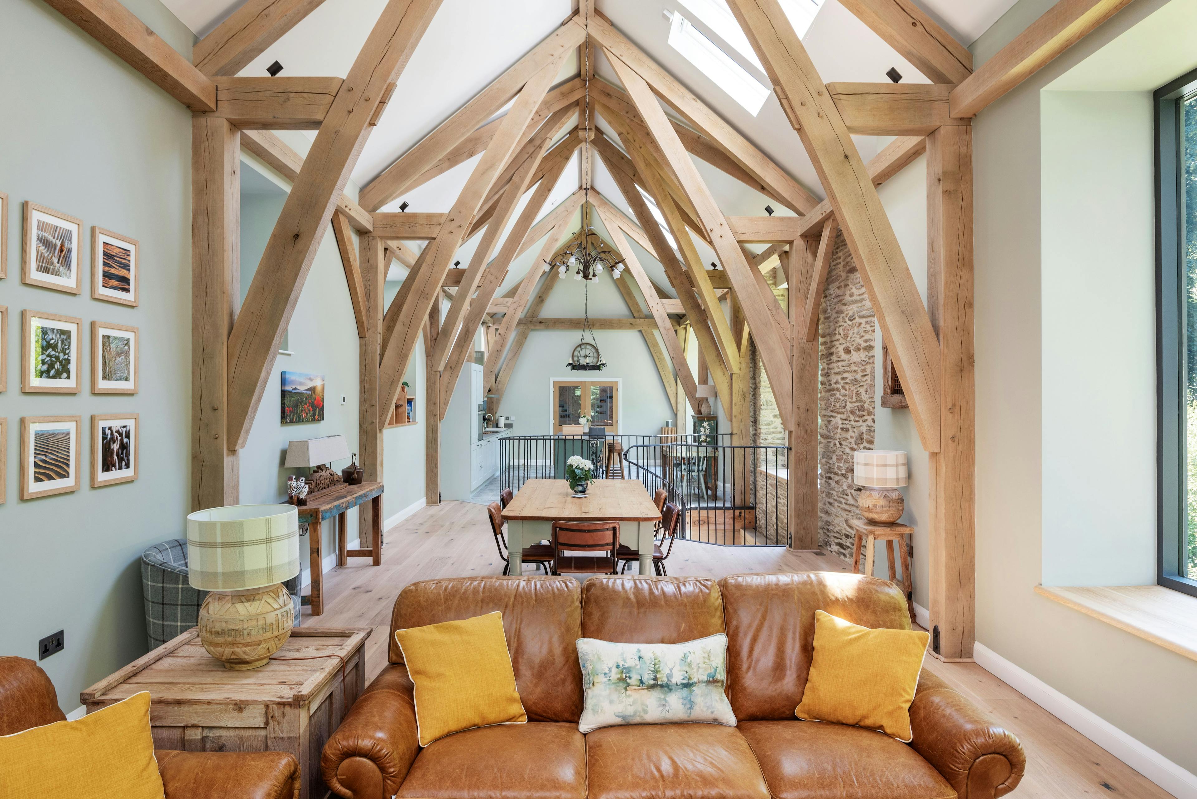Interior view of an open-plan living area with a structural oak frame, offering a warm and welcoming atmosphere