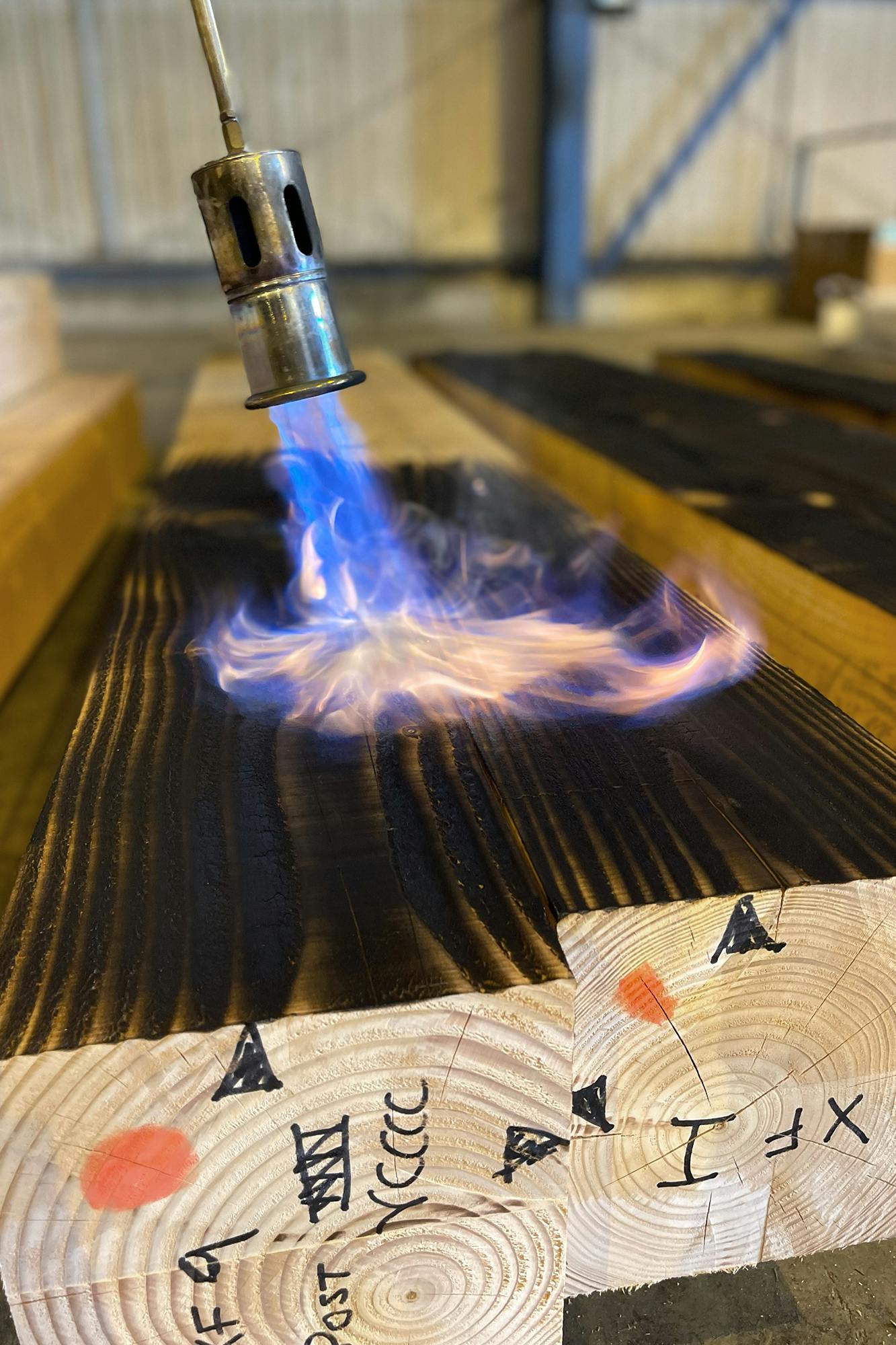 Timber being burnt with a blow torch