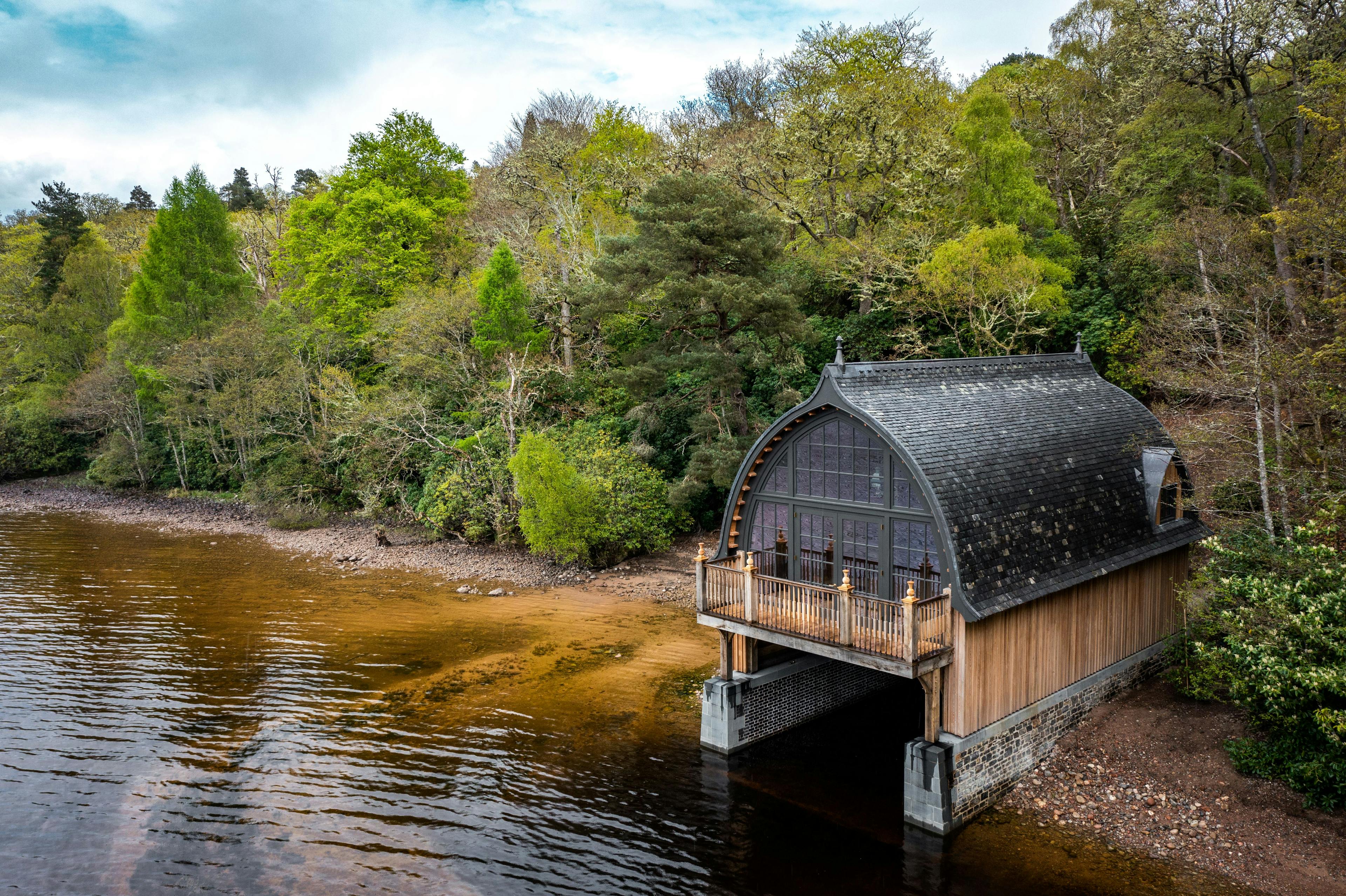 Loch side timber framed boathouse on loch ness with a curved roof