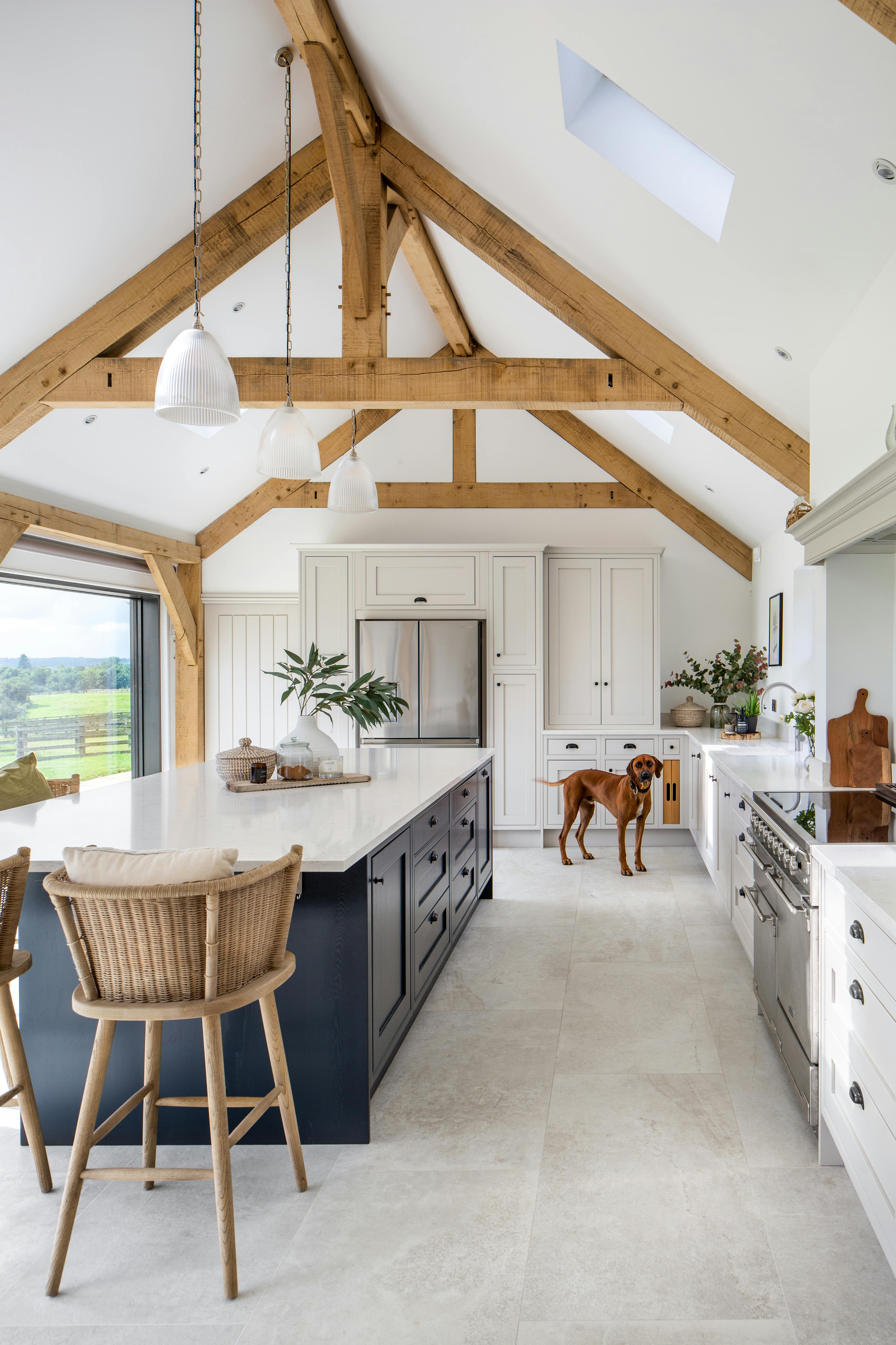 Inside view of a vaulted kitchen showcasing oak framing, raised collar trusses, and an open layout that includes a central island
