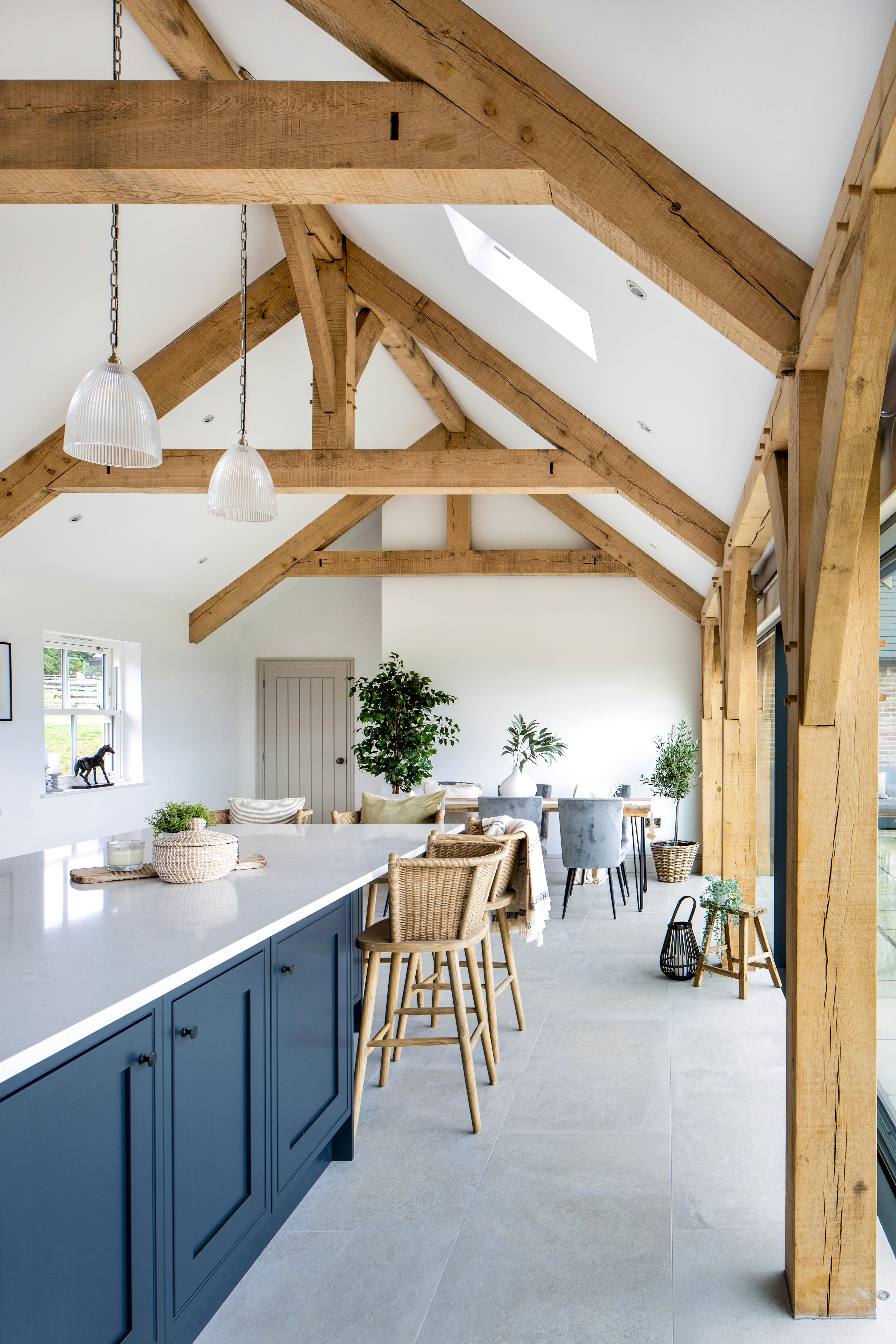 Interior view of a vaulted kitchen with oak framing, showcasing an open-plan layout in a charming farmhouse style