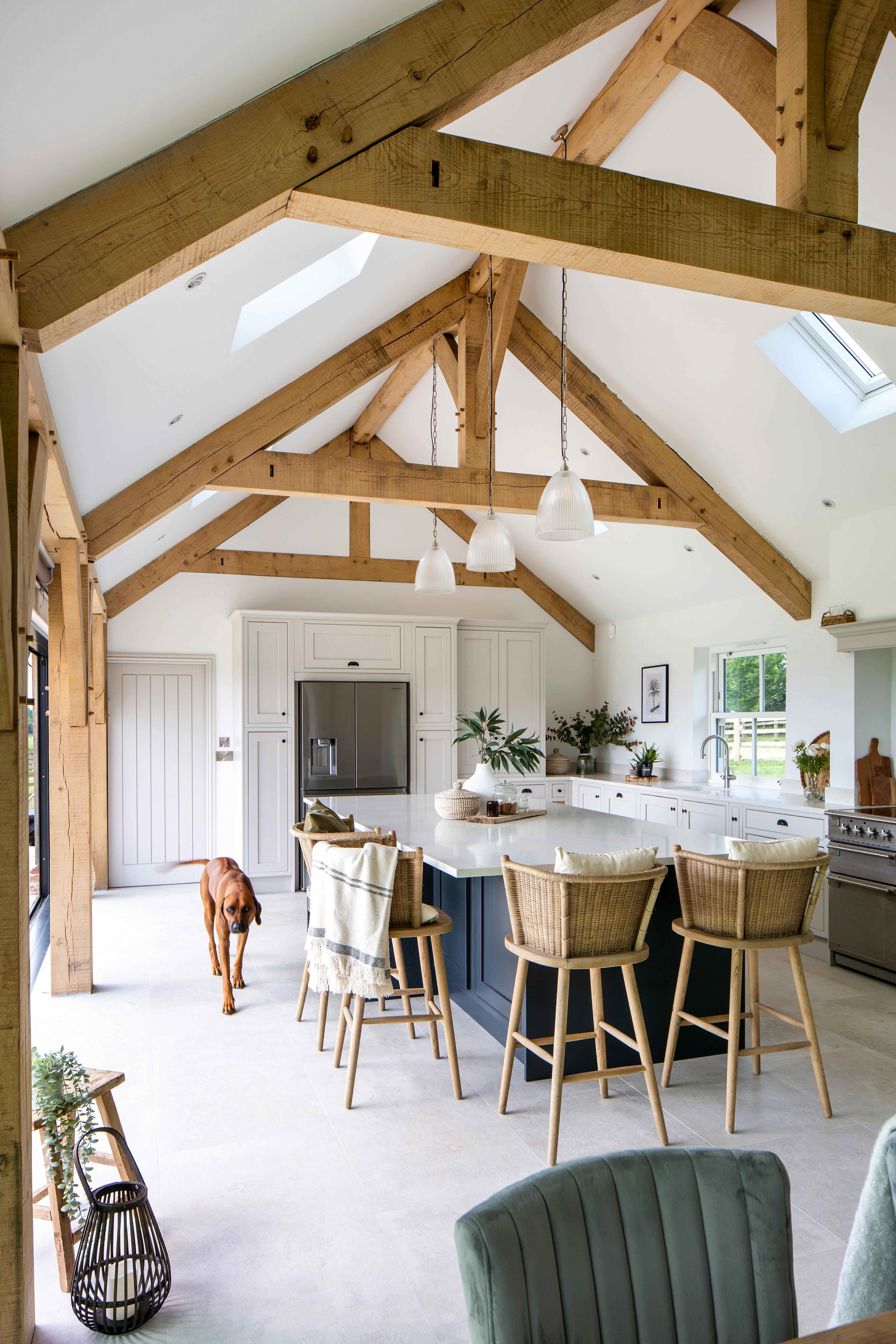 Interior view of a stunning vaulted kitchen with oak framing and raised collar trusses, featuring an open-plan design centered around a stylish island
