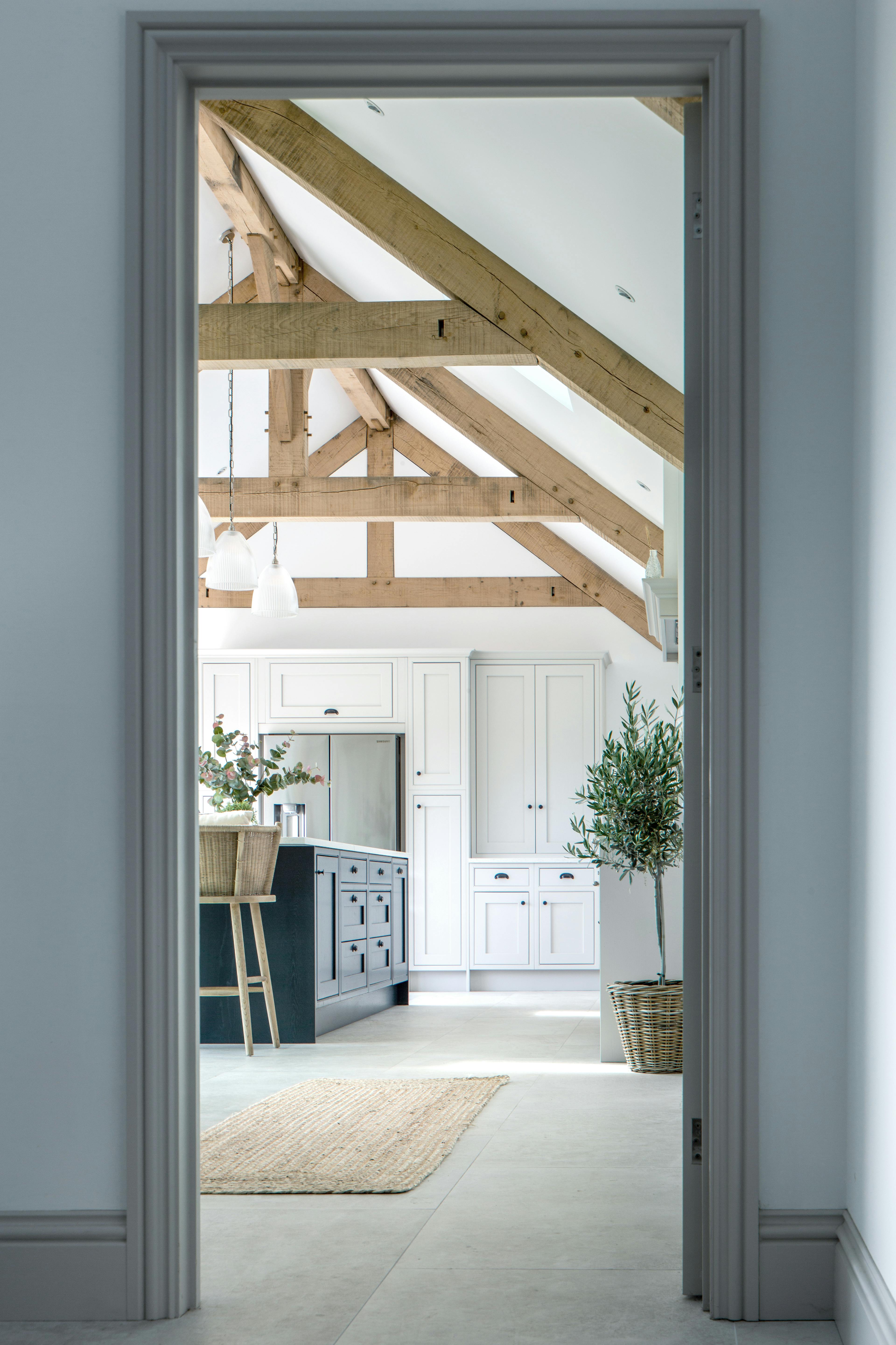 Interior view of a vaulted kitchen with oak framing and a glazed joinery screen
