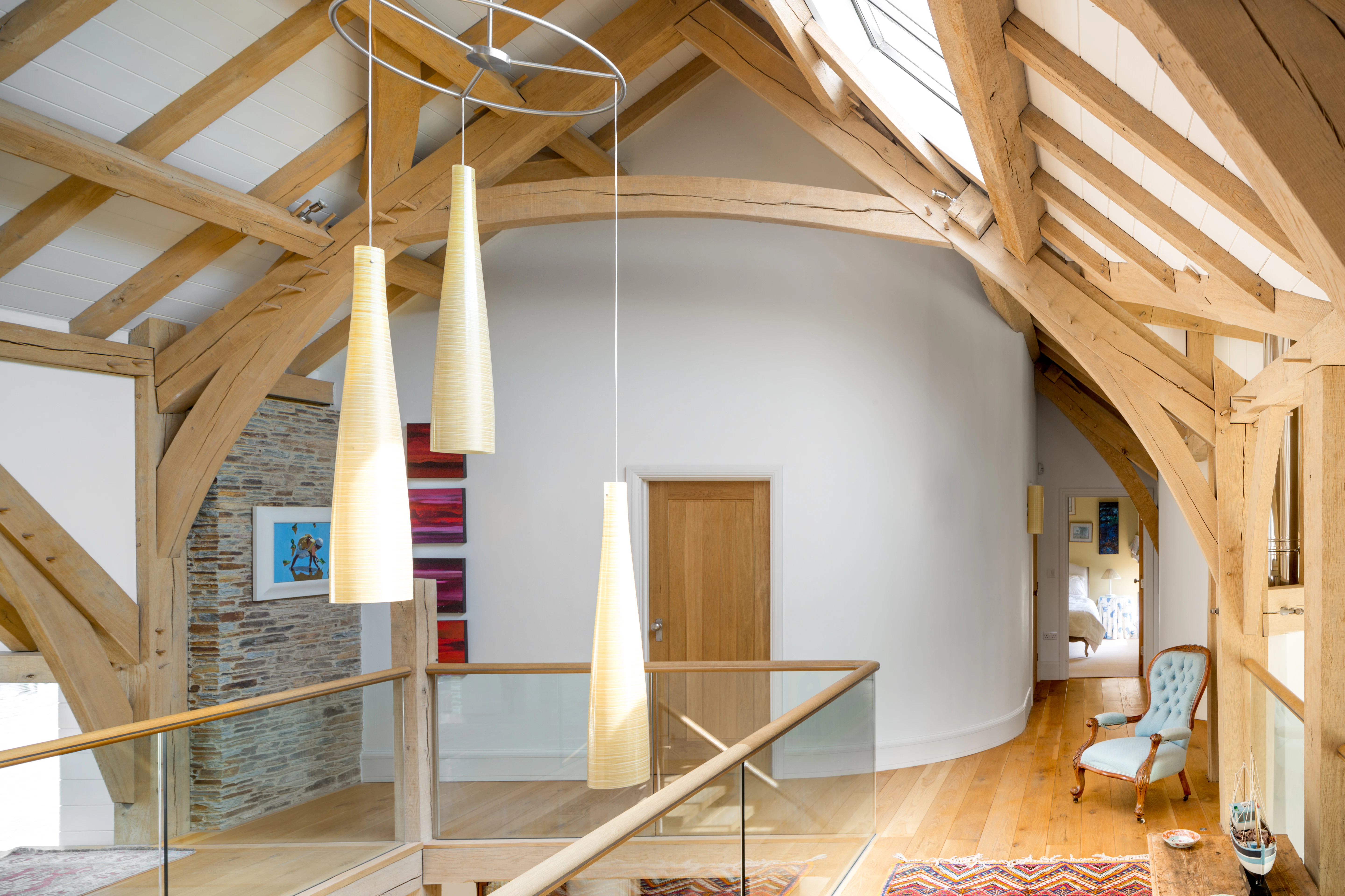 Interior view of a landing with a vaulted ceiling, supported by a combination of sling brace and arch brace oak trusses