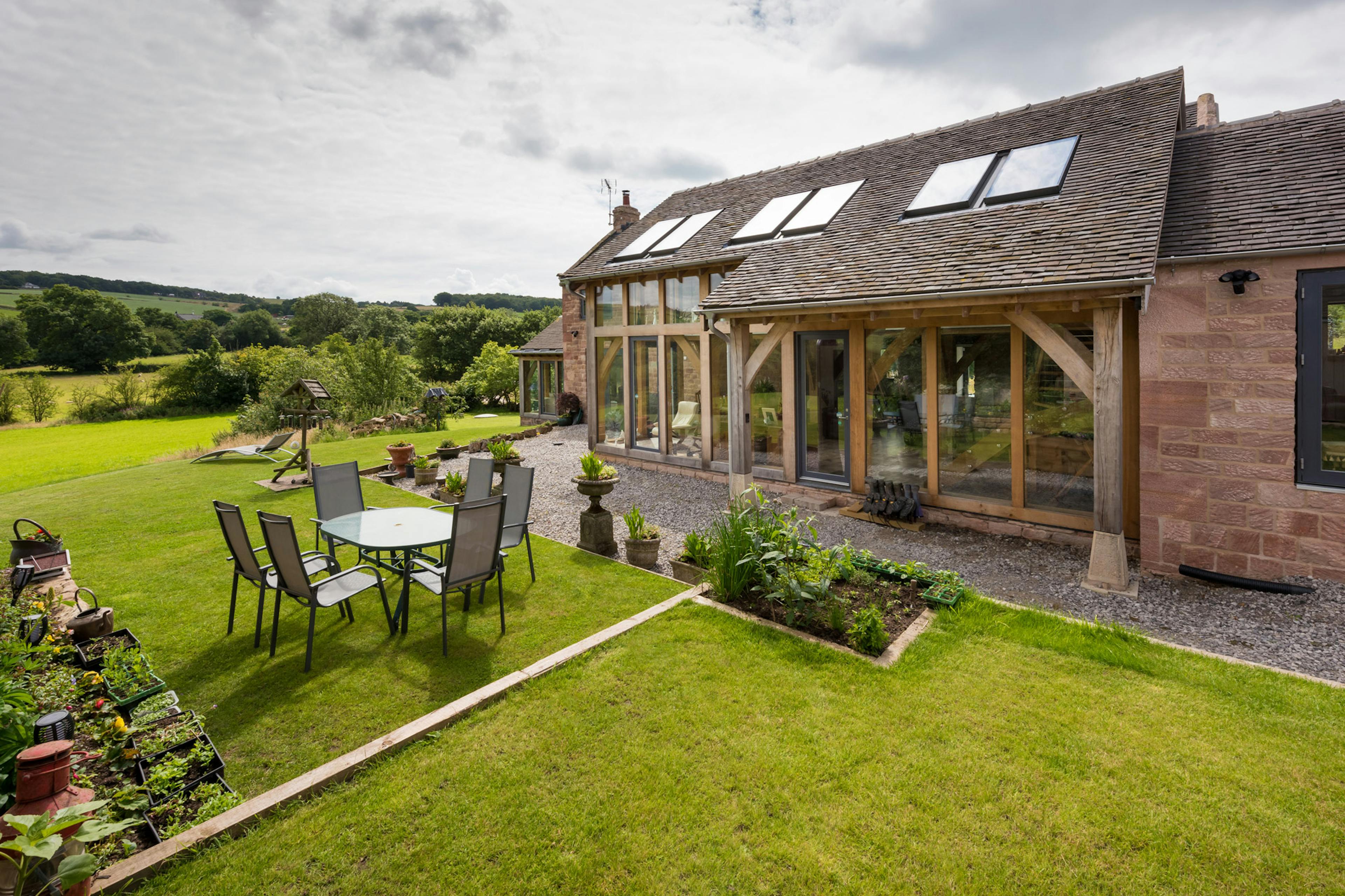 Exterior view of a two-story oak-framed extension with direct glazing