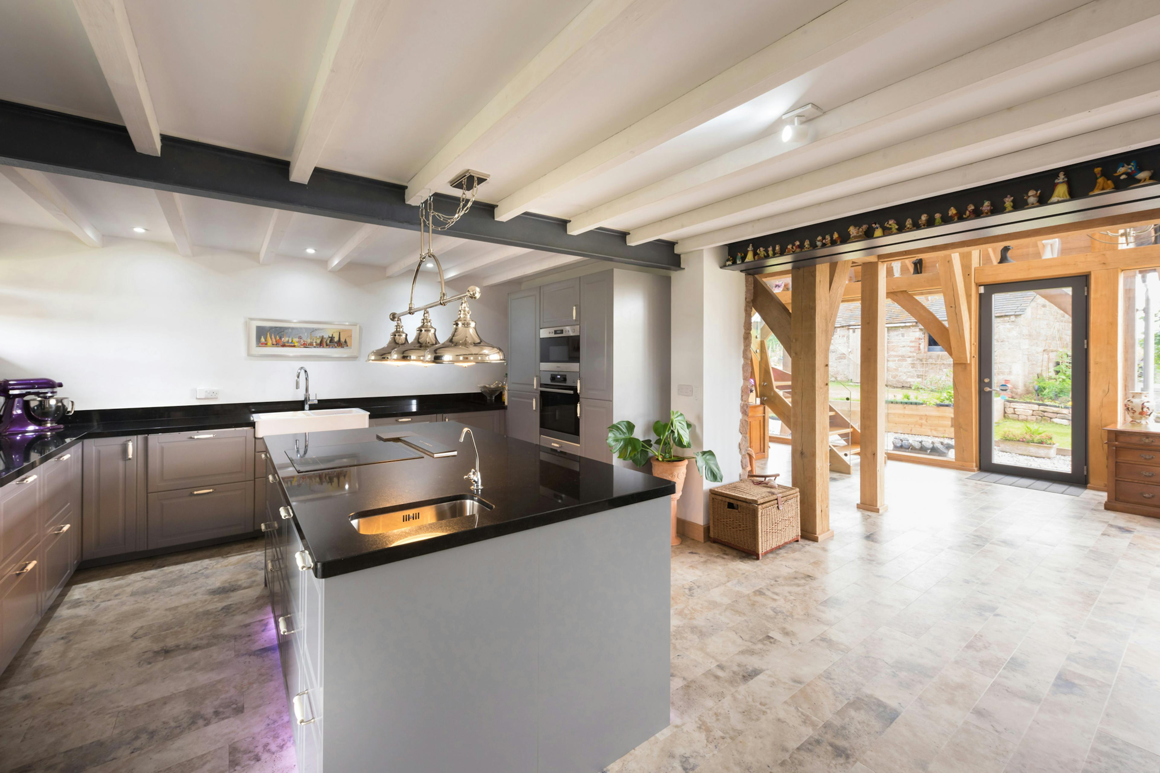 Interior view of an open-plan kitchen and dining area within a two-story oak-framed extension