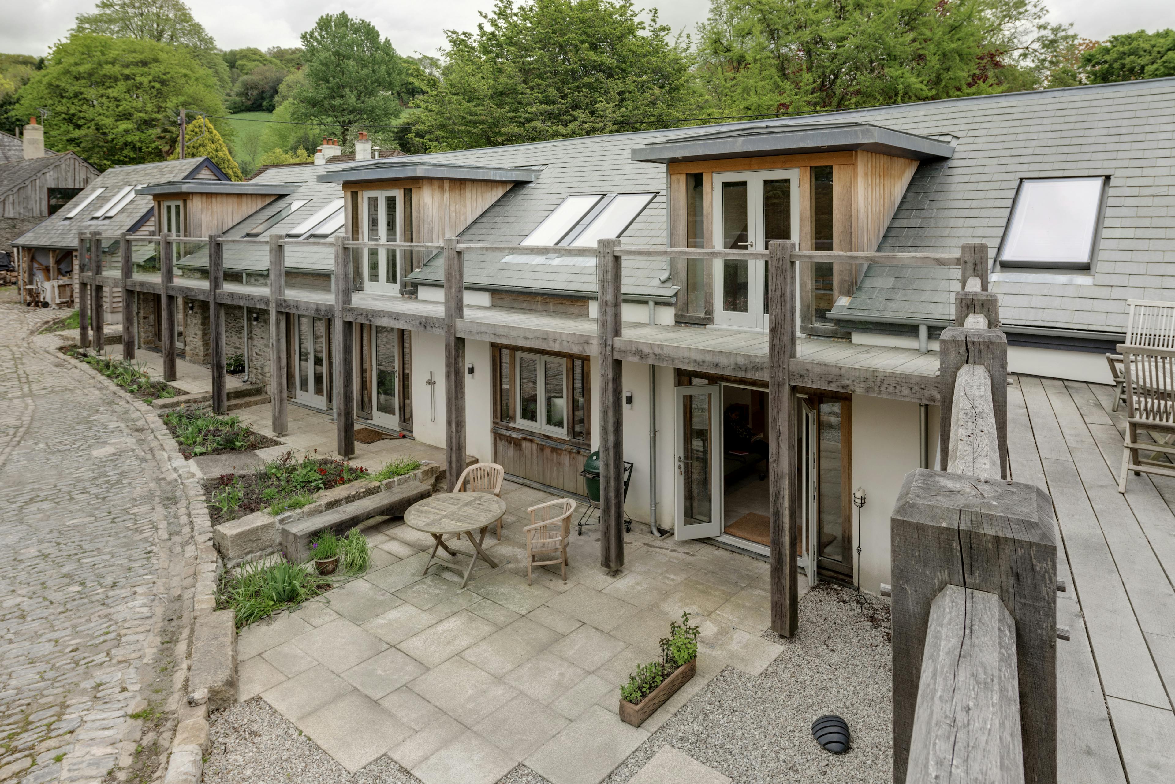 Exterior view of a wrap-around oak-framed balcony on a two-story home
