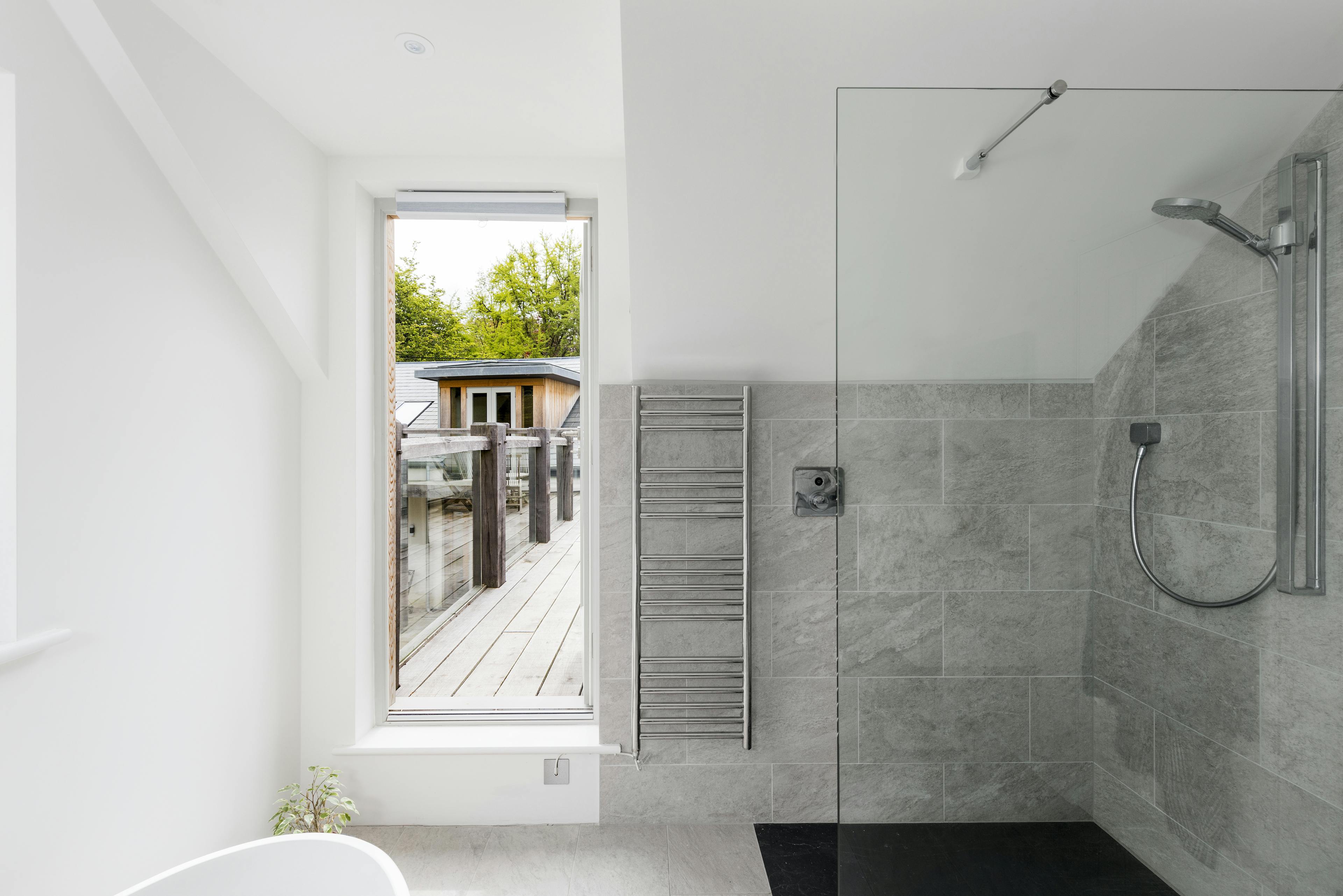 Interior view of a bathroom featuring a walk-through door leading to a wrap-around oak-framed balcony