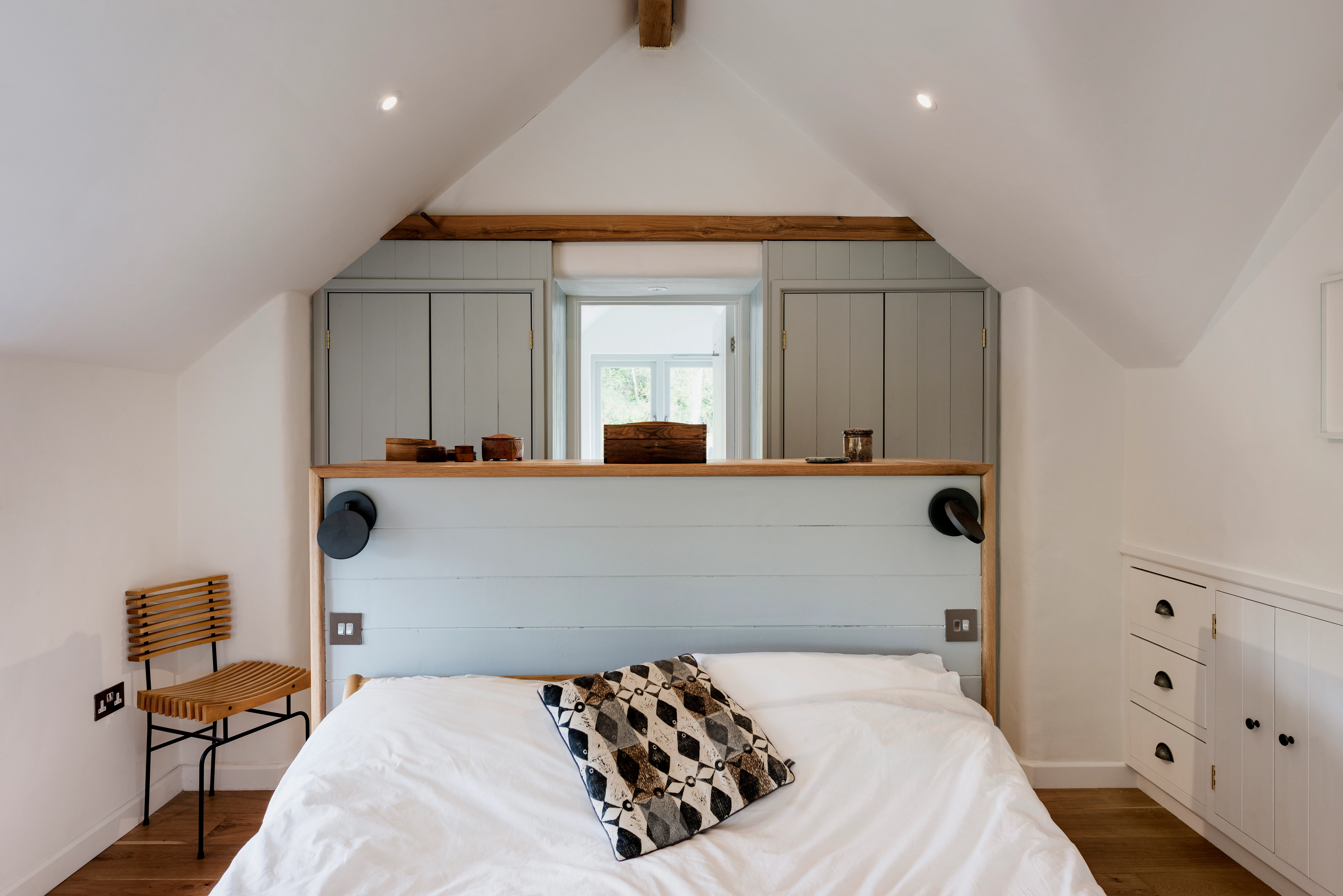 Interior view of a unique master bedroom featuring built-in storage and a walk-through en-suite bathroom