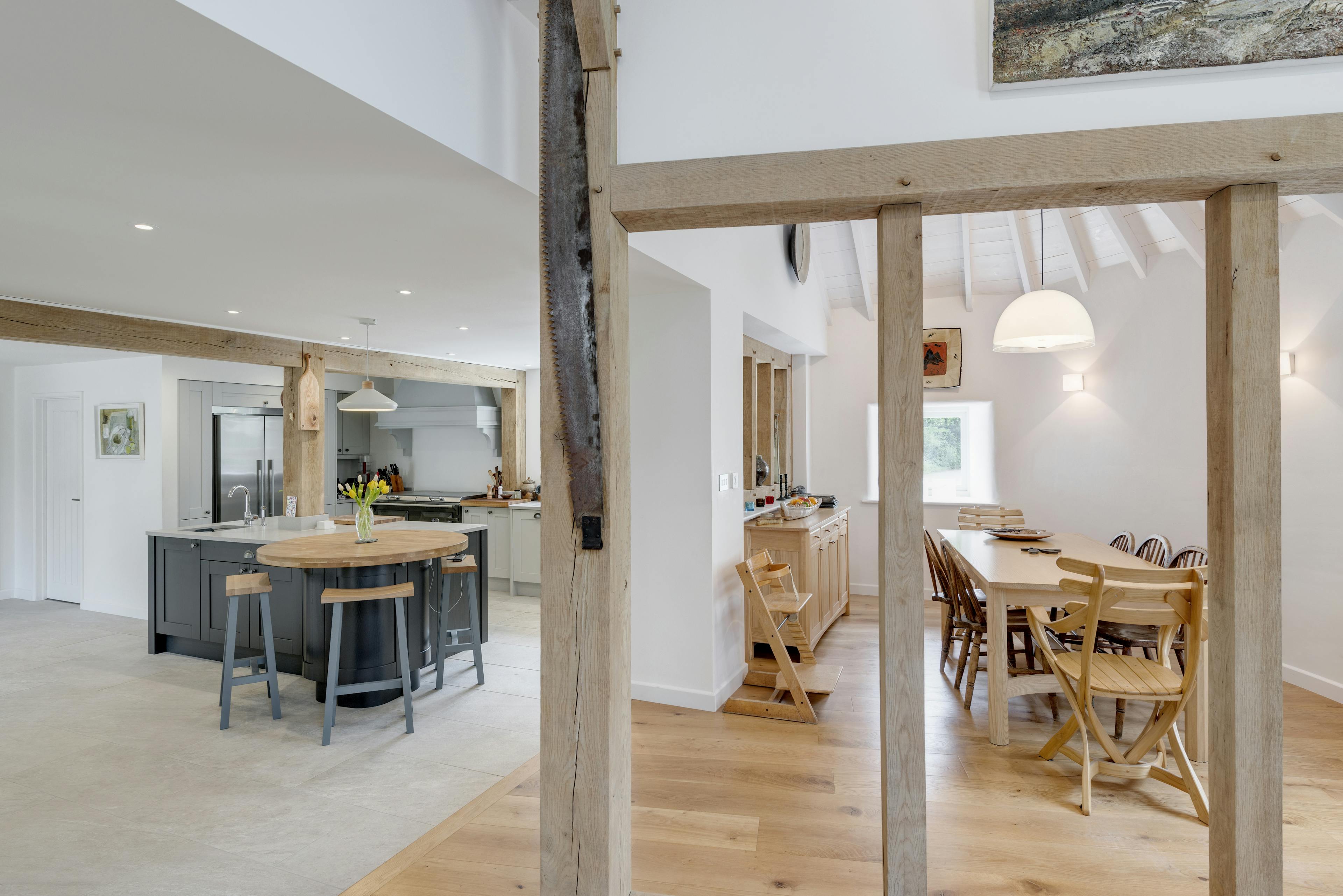 Interior view of an open-plan kitchen and dining area with oak frame wall dividers