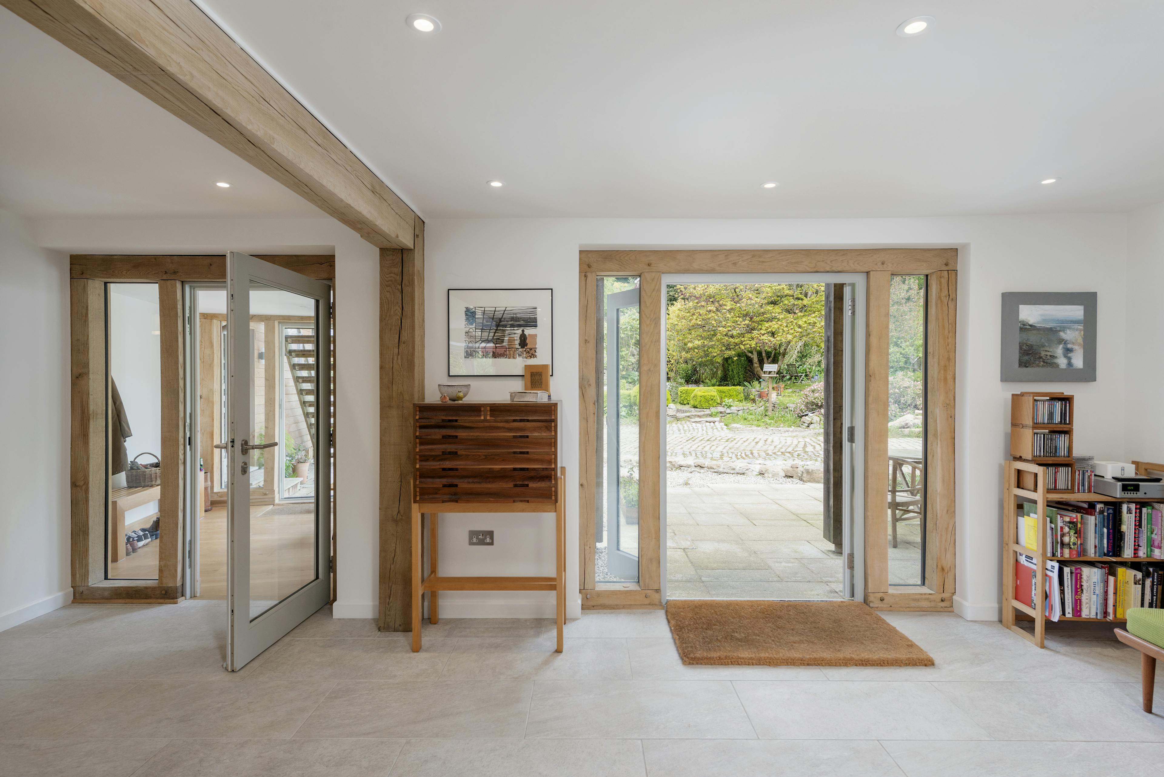 Interior view of the foyer of an oak-framed house, featuring oak-framed, direct-glazed external doors and windows