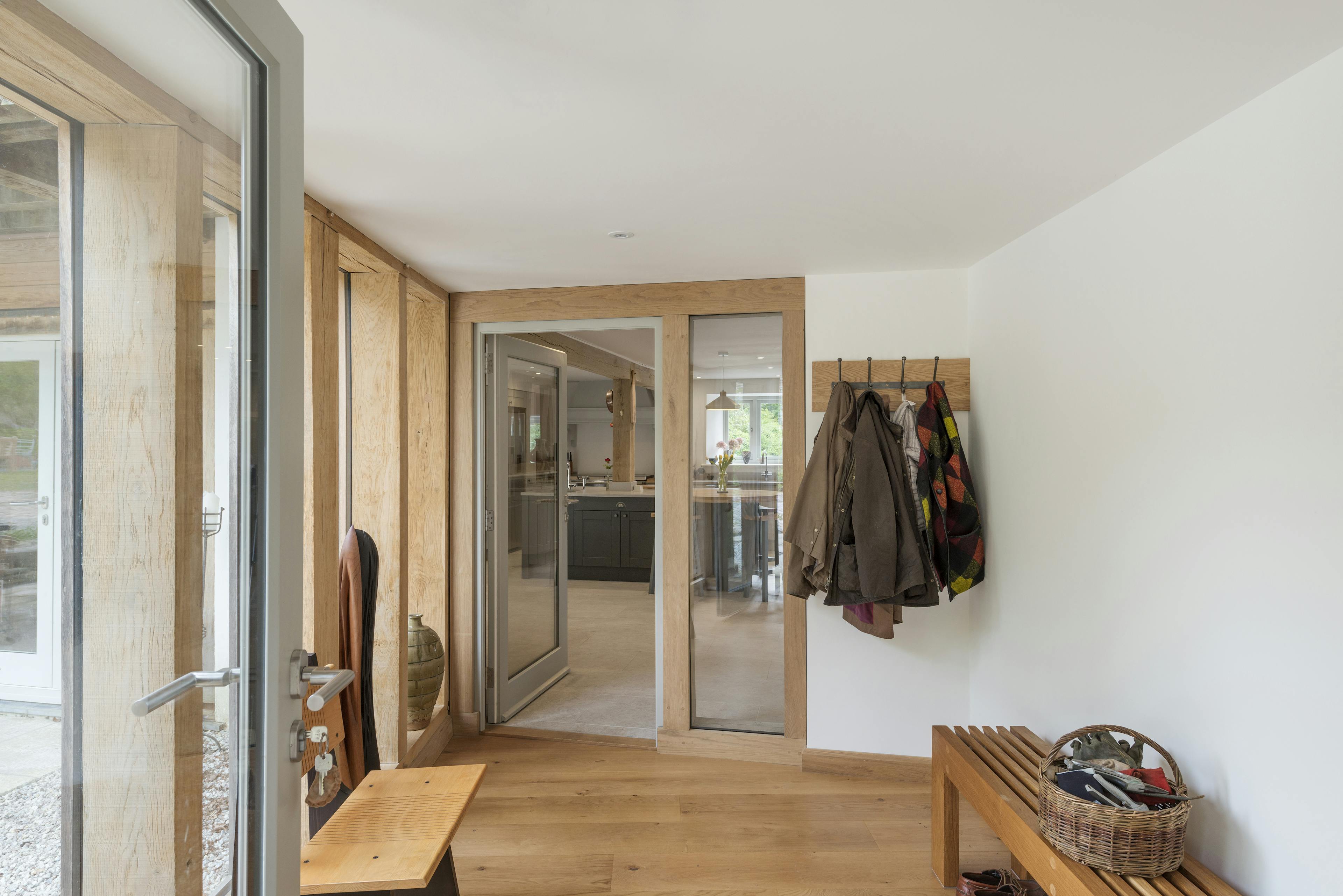 Interior view of an oak-framed porch, illuminated by full-length glazed windows