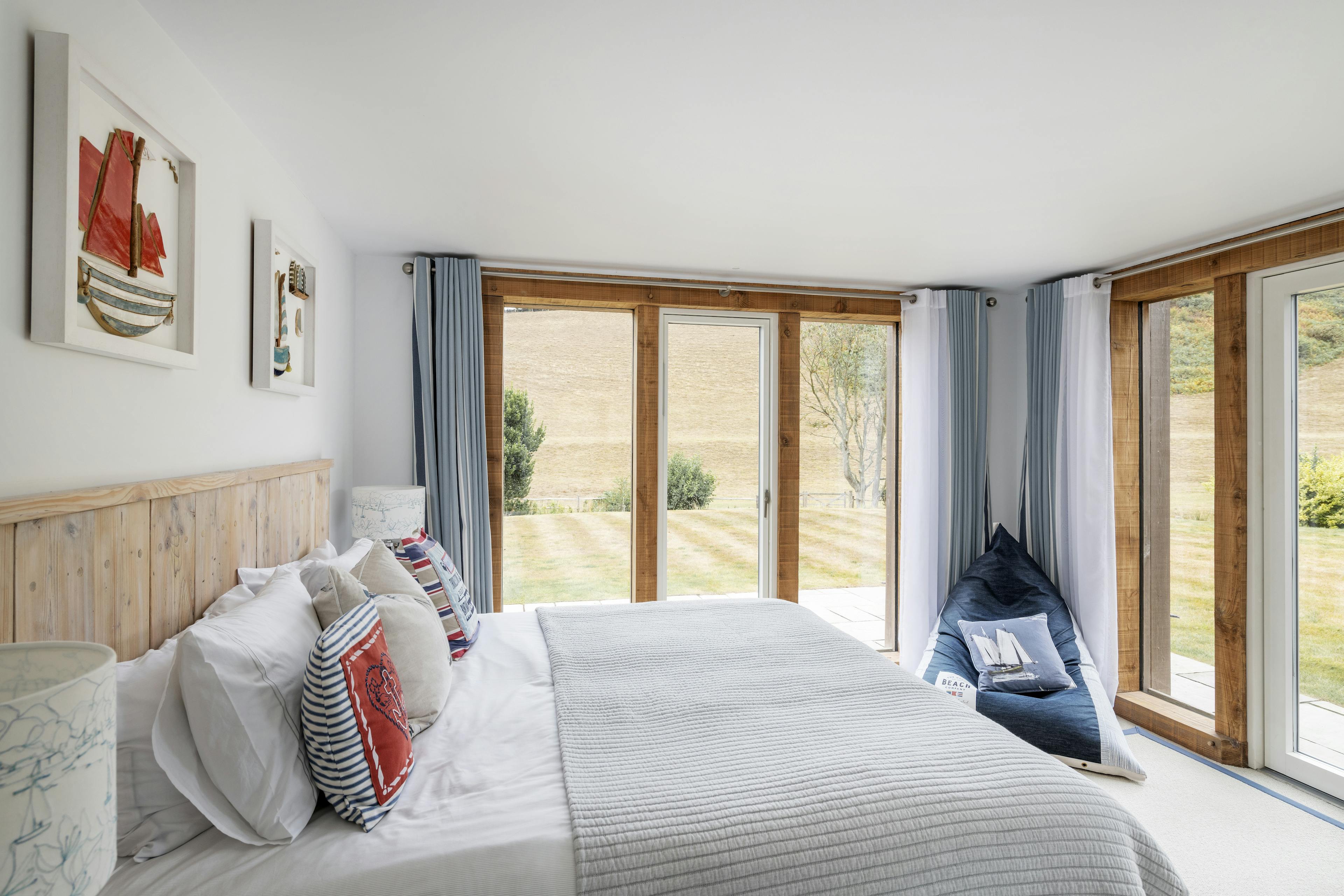 Modern oak framed bedroom with views of fields