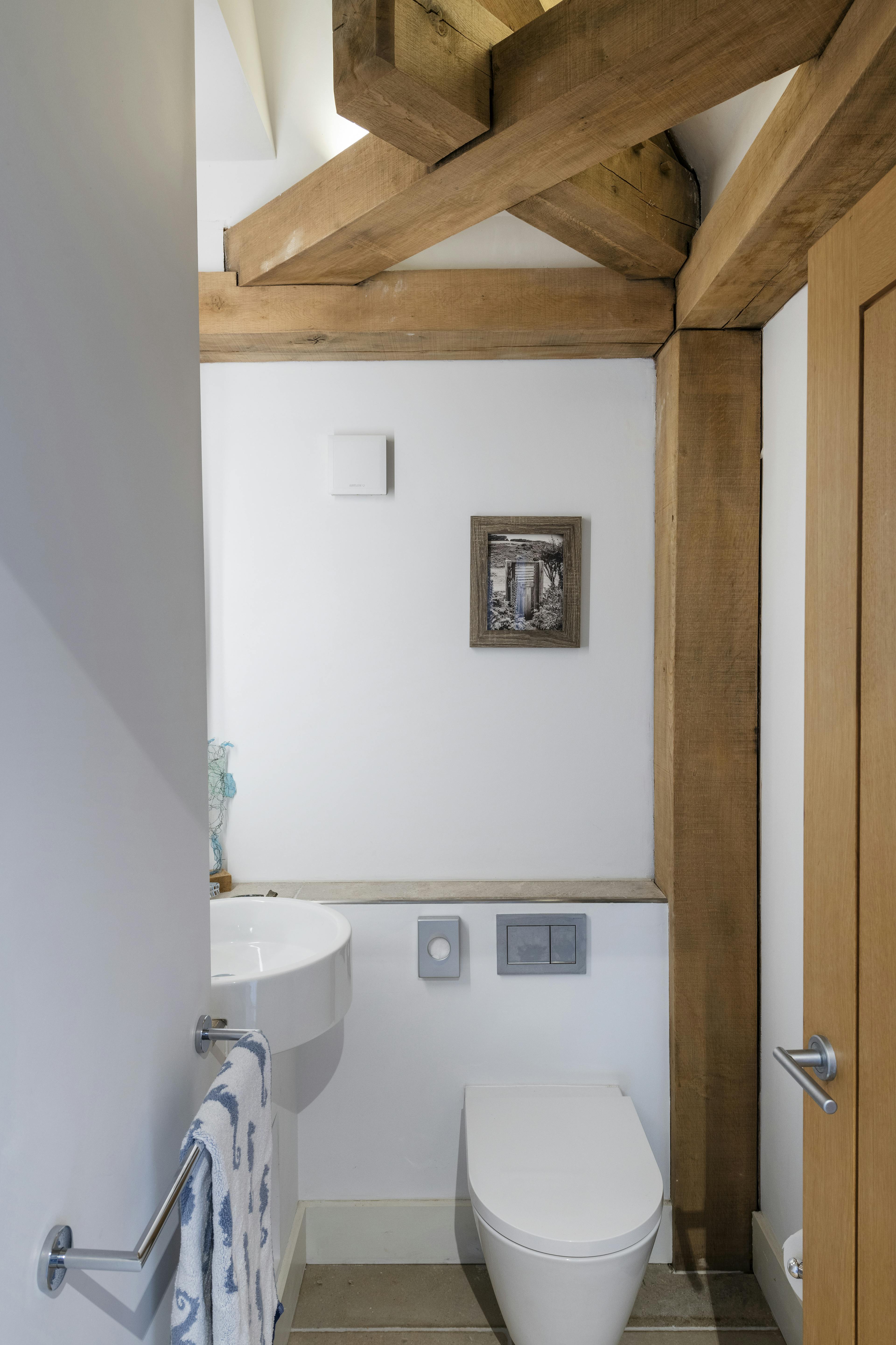 An oak framed bathroom showing a toilet and sink