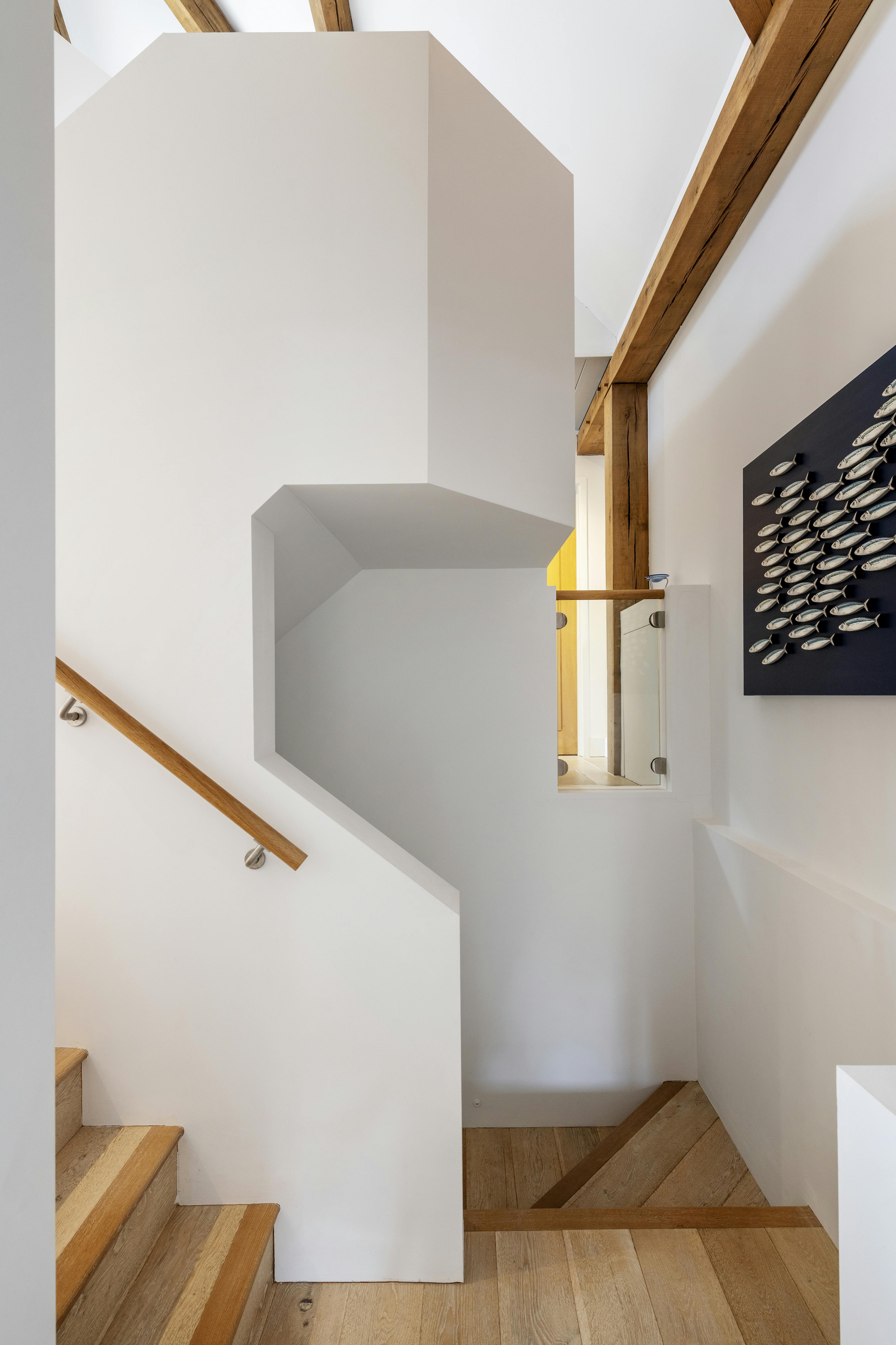 Modern white curved staircase in an oak framed home