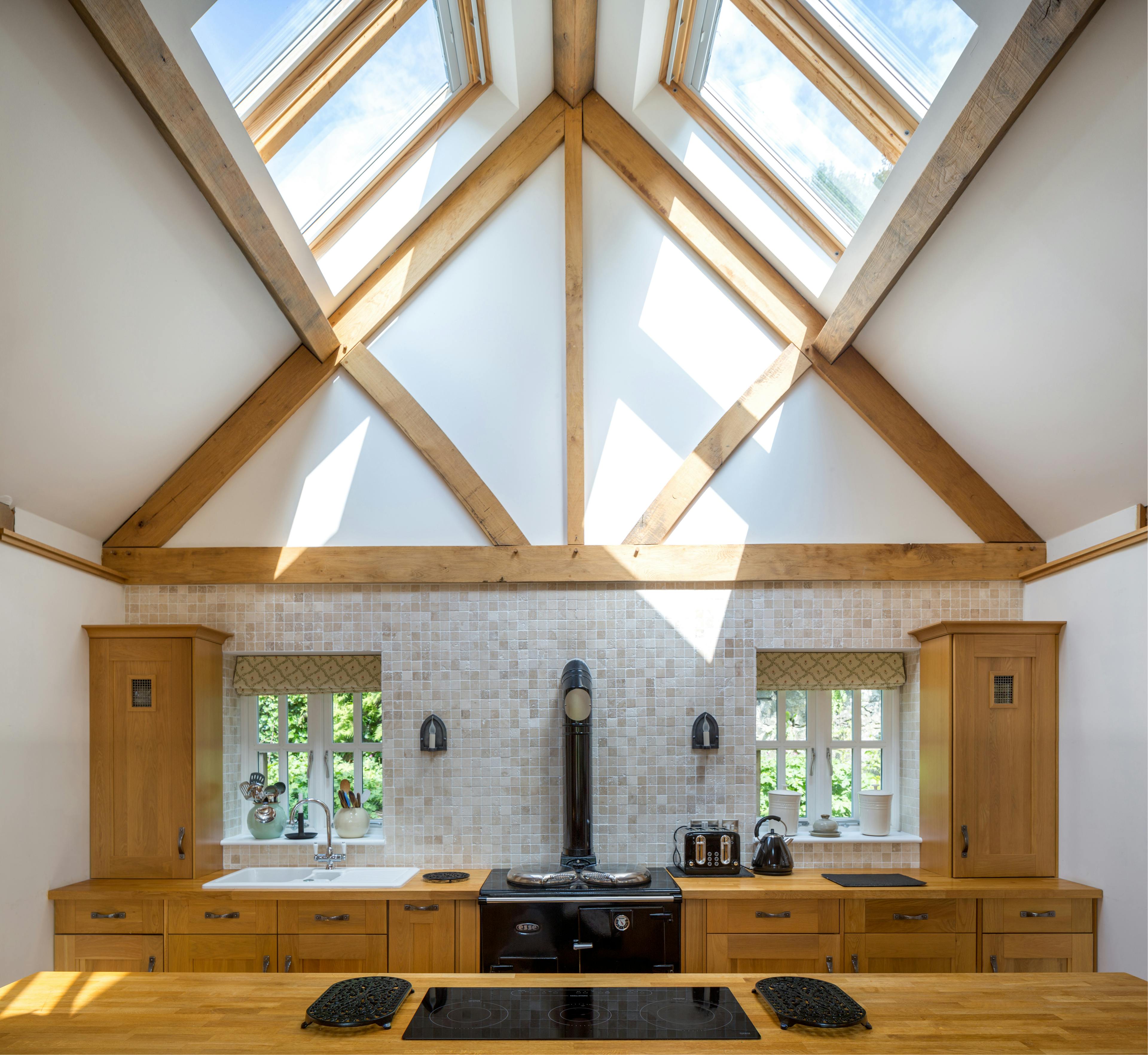 An oak framed kitchen with sun coming through a rooflight
