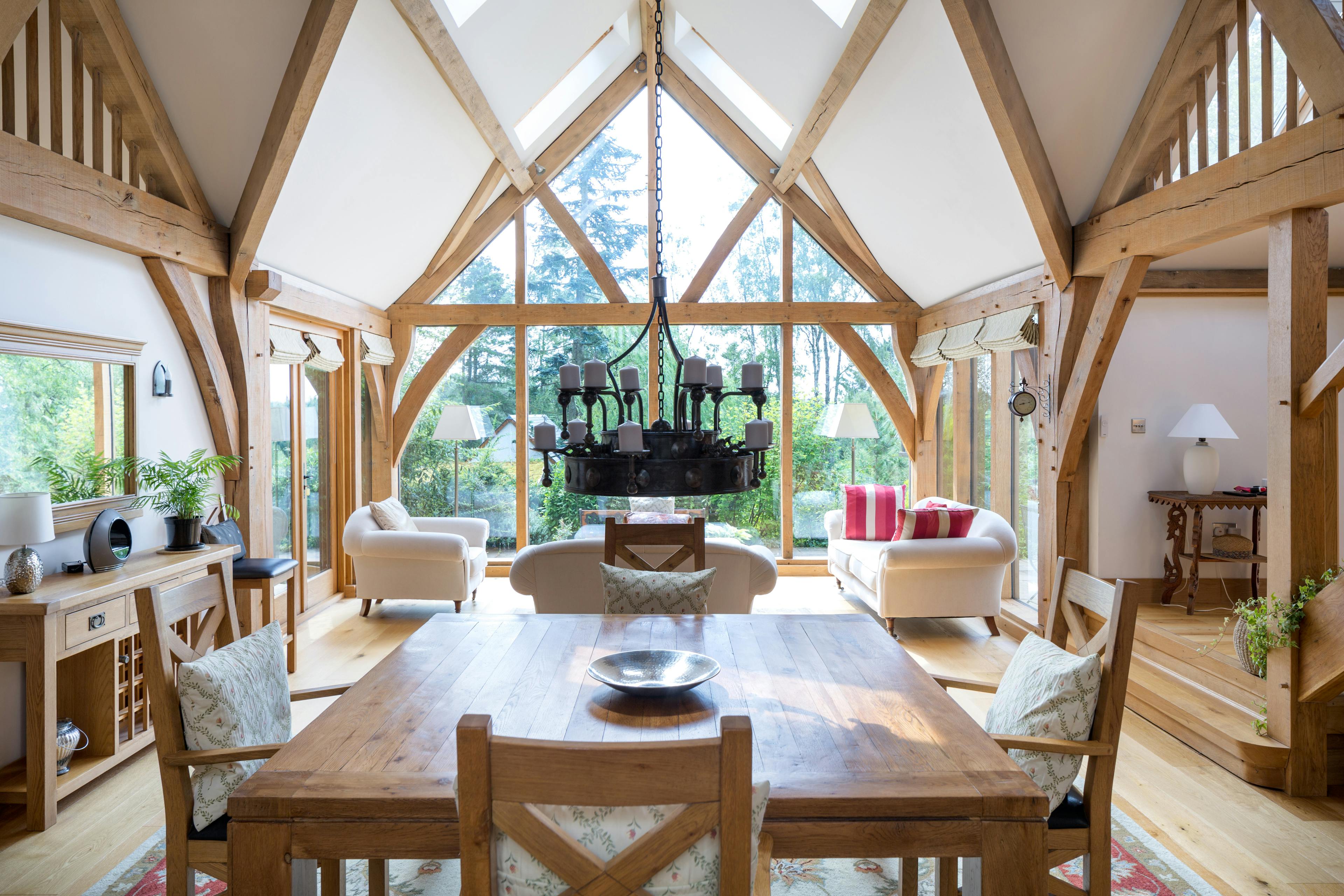 Oak framed living room with a large glazed gable end, showing the dining table