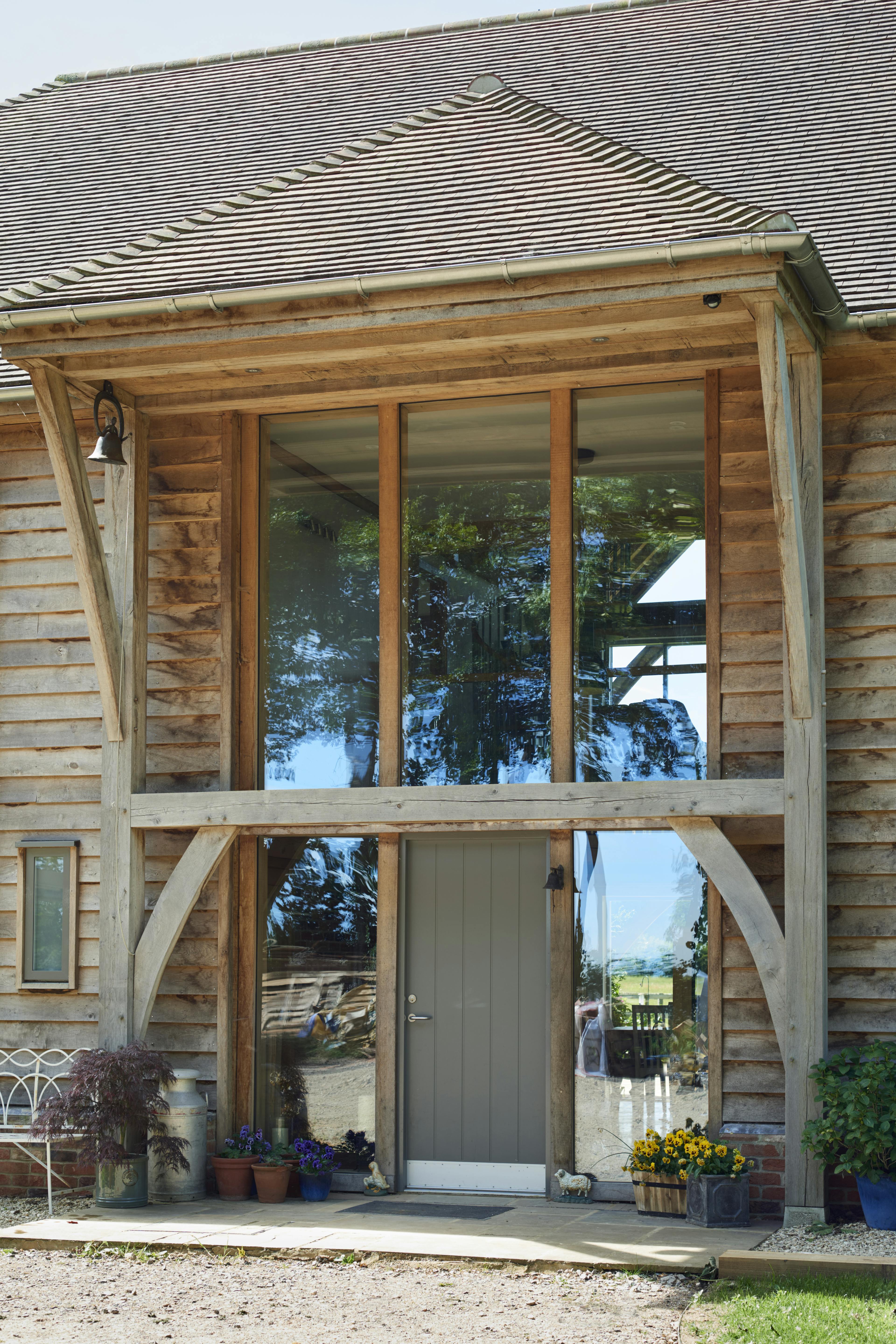 Green front door on an oak framed home with timber cladding